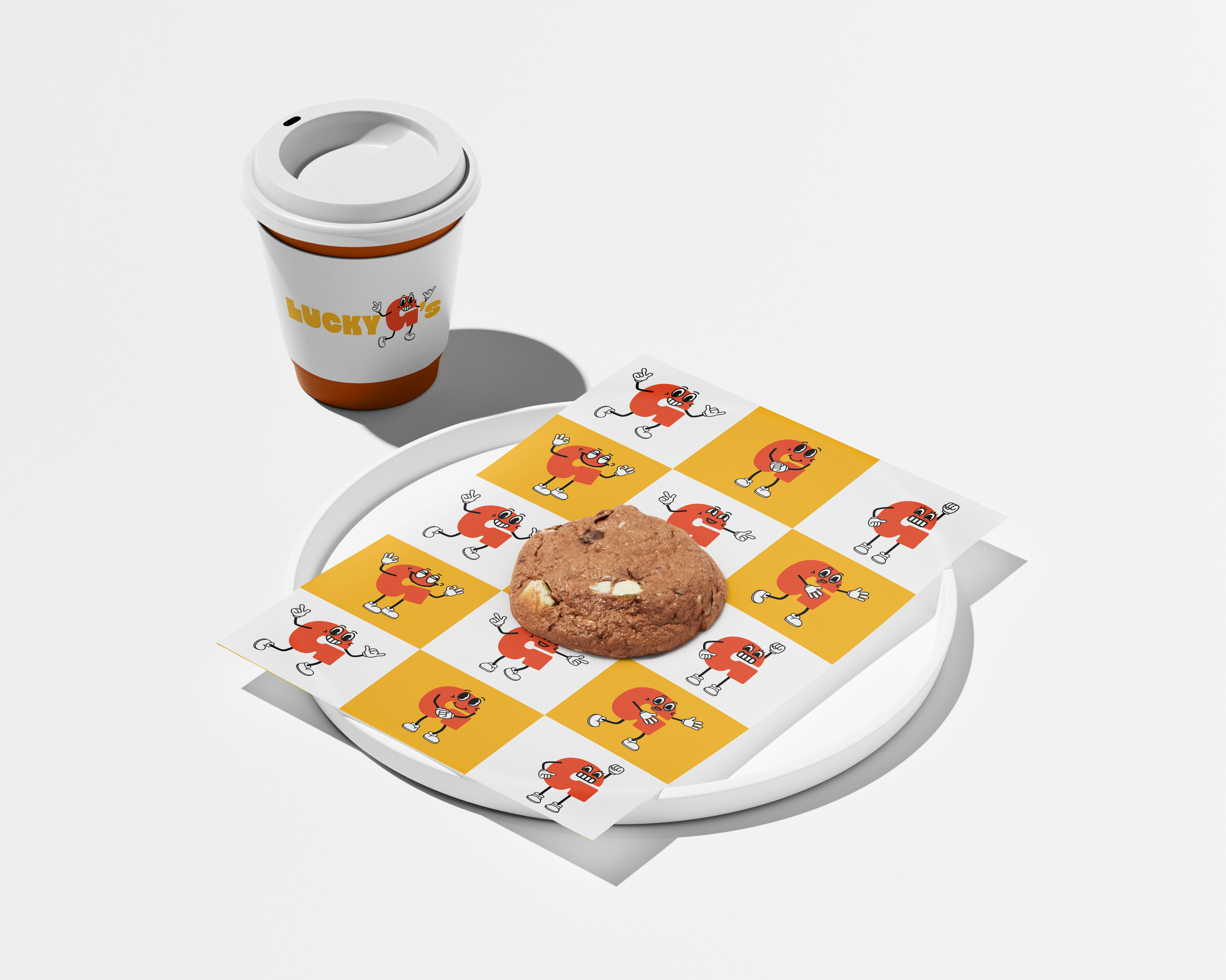 White paper with cartoon red characters on a checkered yellow and white background, a cookie with white chocolate chips, a white disposable coffee cup with the word "Lucky's" and a cartoon character on it, all on a white plate.