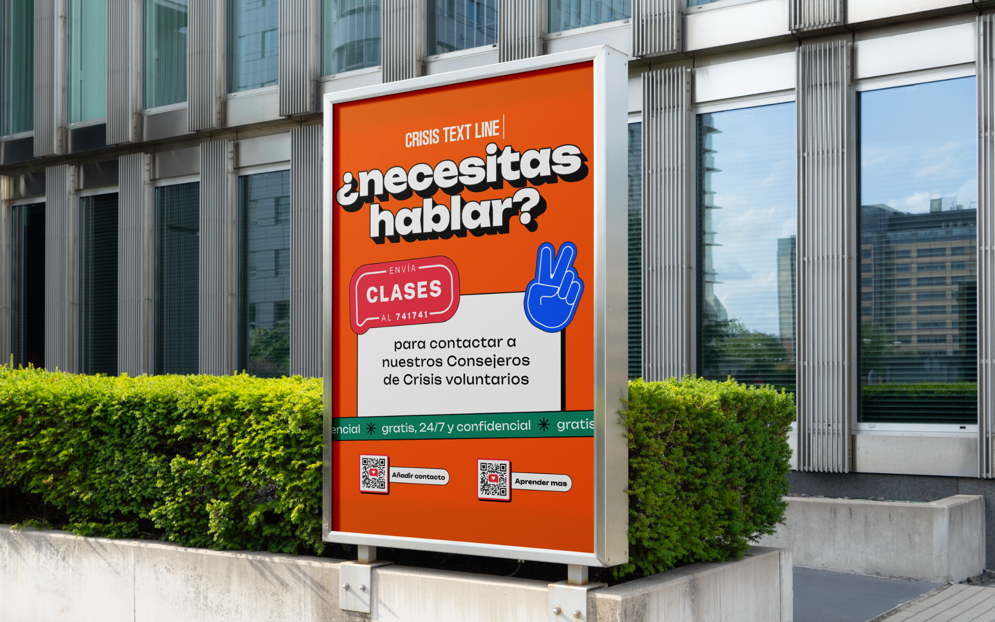 An outdoor signboard in front of a modern building advertises free confidential crisis counseling classes with QR codes for contact and learning more, against a backdrop of glass windows and green bushes.