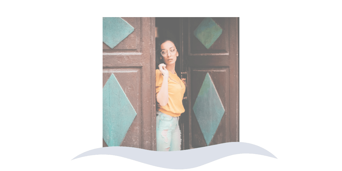 Woman peering hesitantly through a doorway, representing the caution and avoidance that can come with a phobia