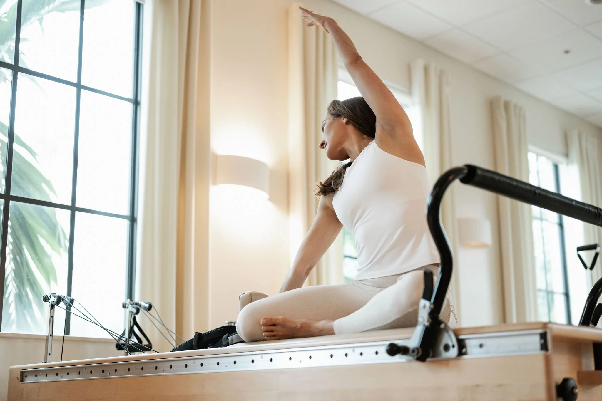 Lisa Harvey practicing Pilates on a Reformer at Core Elements in Jupiter, FL.