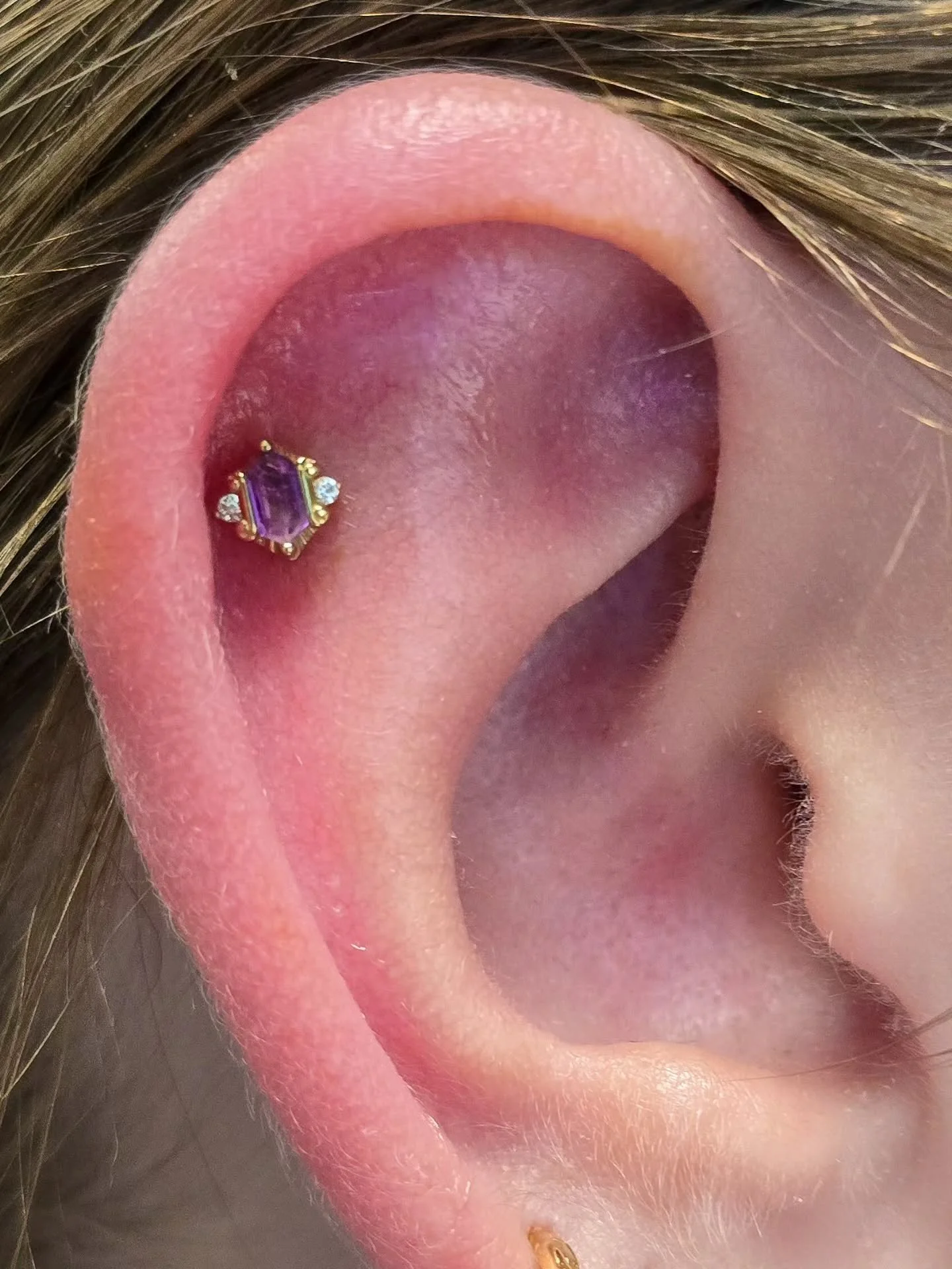 I get so excited when clients find a piece that speaks to them! This amethyst Reyna from @buddhajewelryofficial had just hit the case, and immediately found its forever home nestled in this cartilage piercing. We paired it with a lovely tri-bead in t