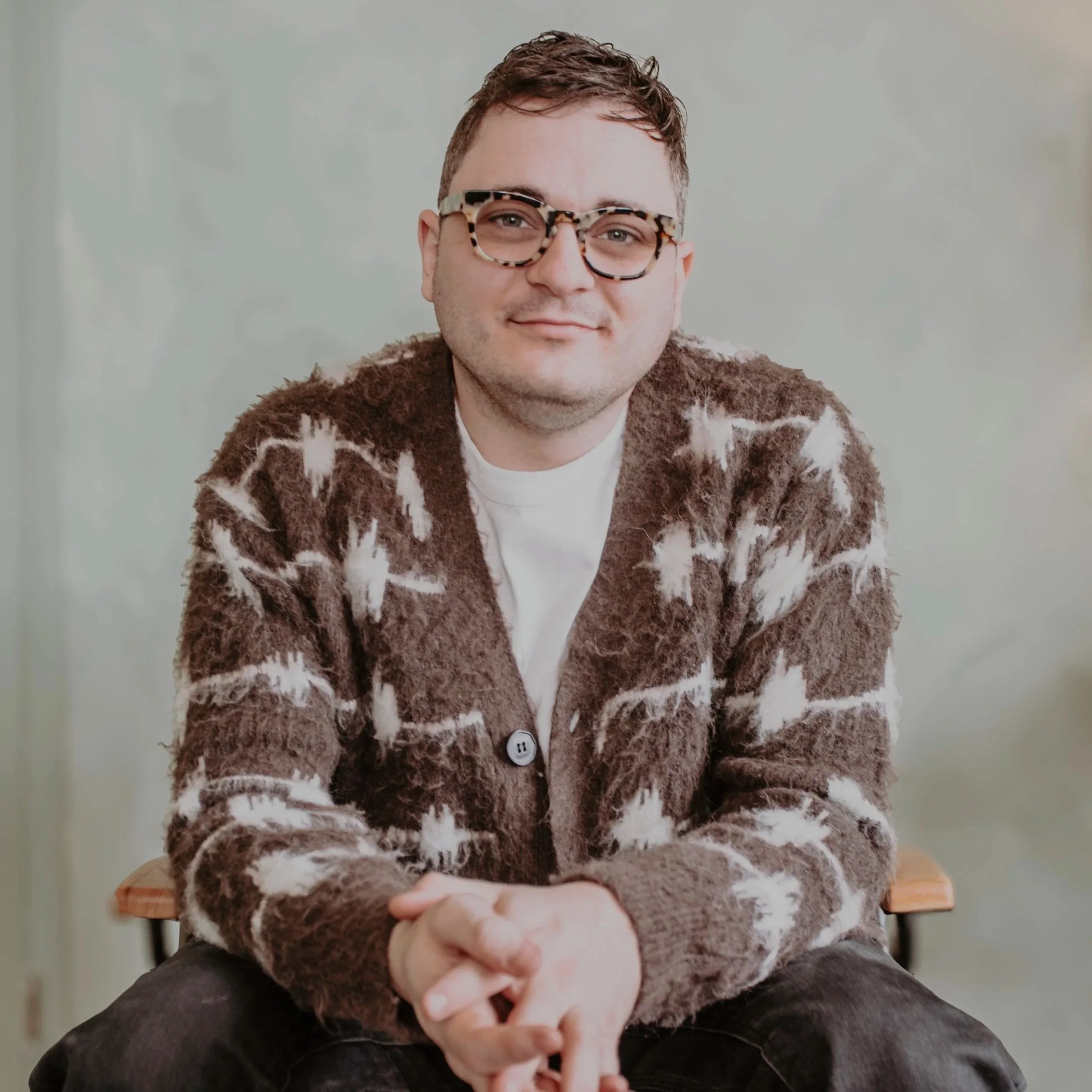 Man sitting in a chair inviting conversation. 