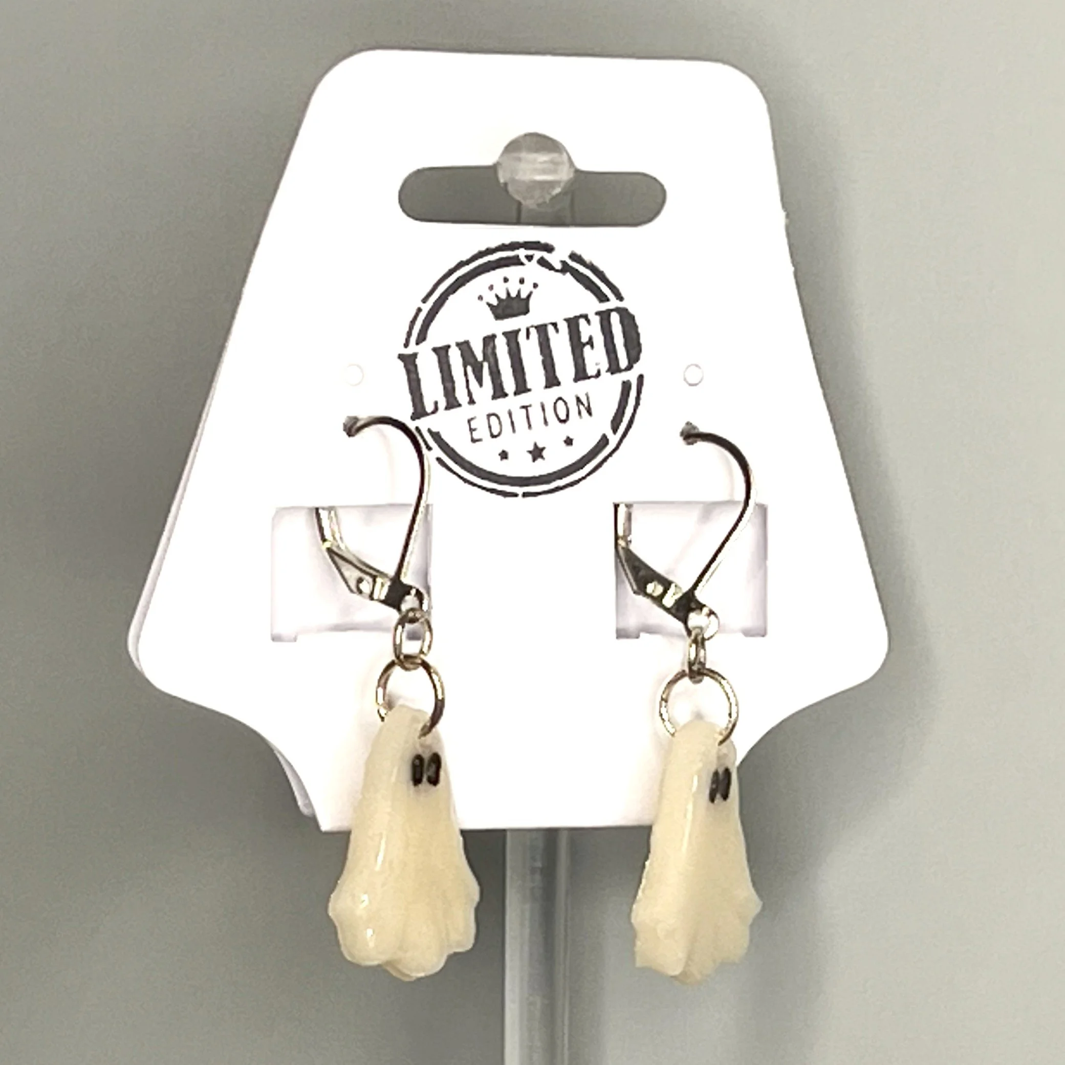 Minimalist translucent ghost earrings without pumpkins, hanging on card for display against a marble-patterned background