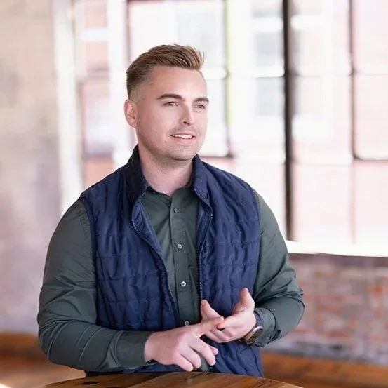 Alex Roberts mid-conversation in a warm, light-filled space.