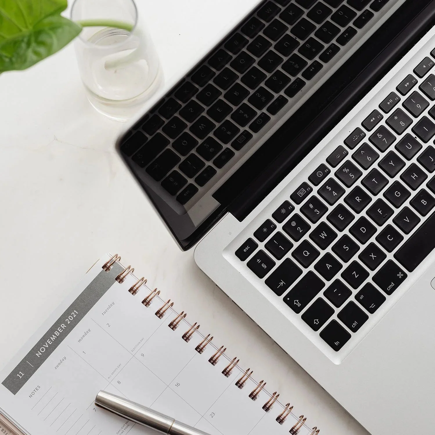 Open planner and pen next to a laptop on a clean desk, representing organized scheduling and the psychological testing process.