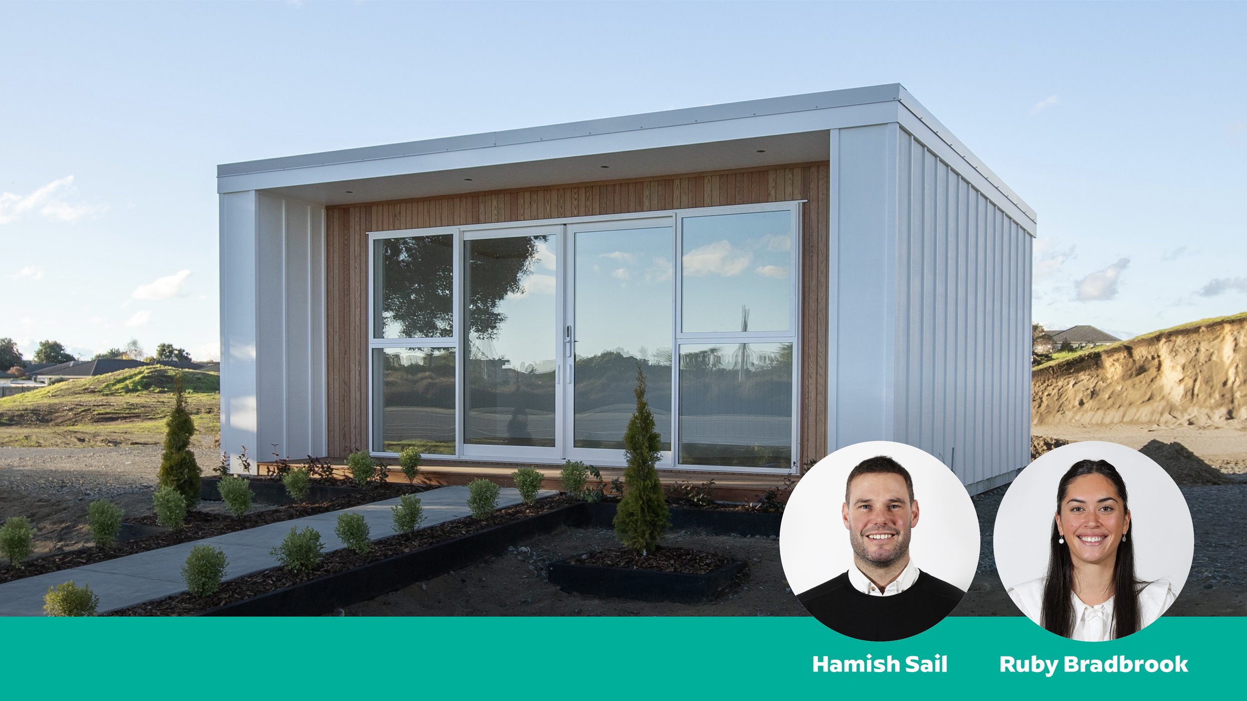 A modern tiny house with large glass sliding doors and wooden accents, surrounded by a landscaped yard with small bushes and tall trees in the background, under a clear blue sky.