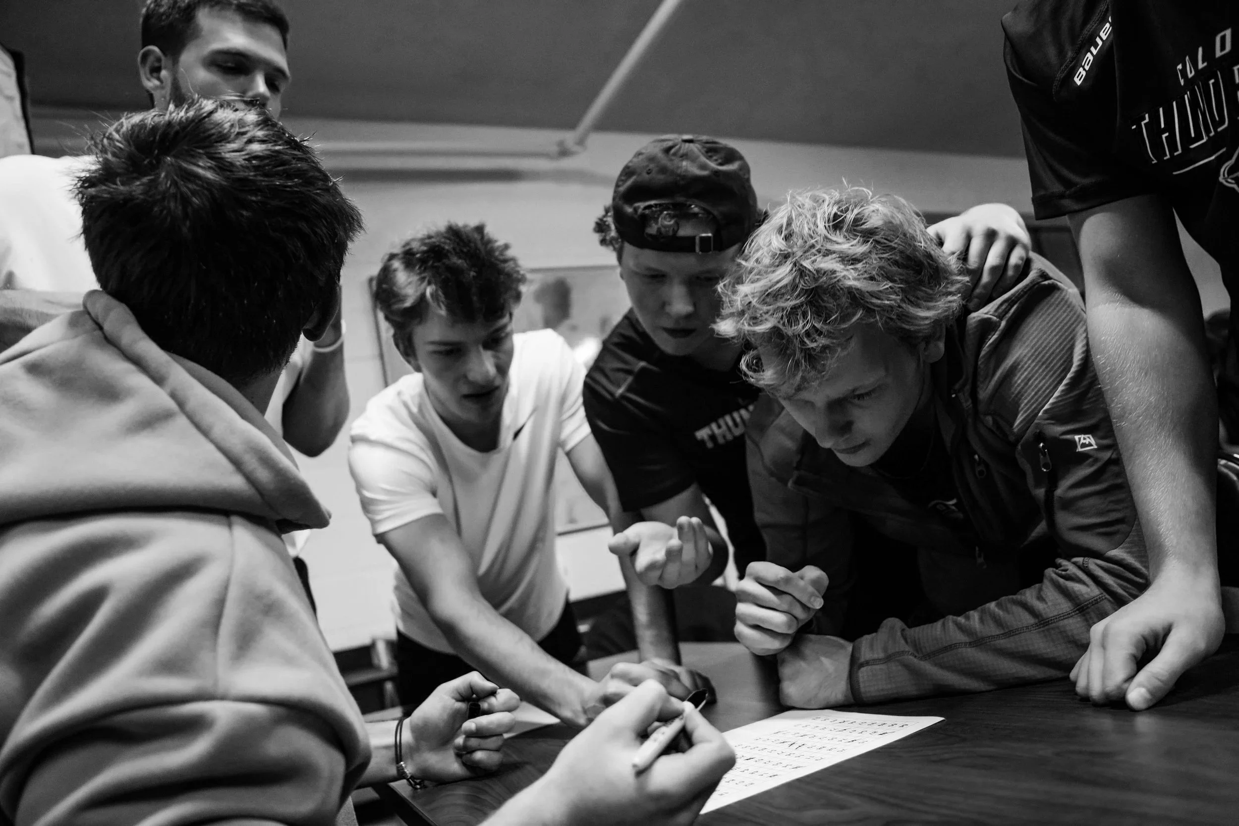 A group of people standing on a hilltop looking at distant mountains under a clear blue sky.