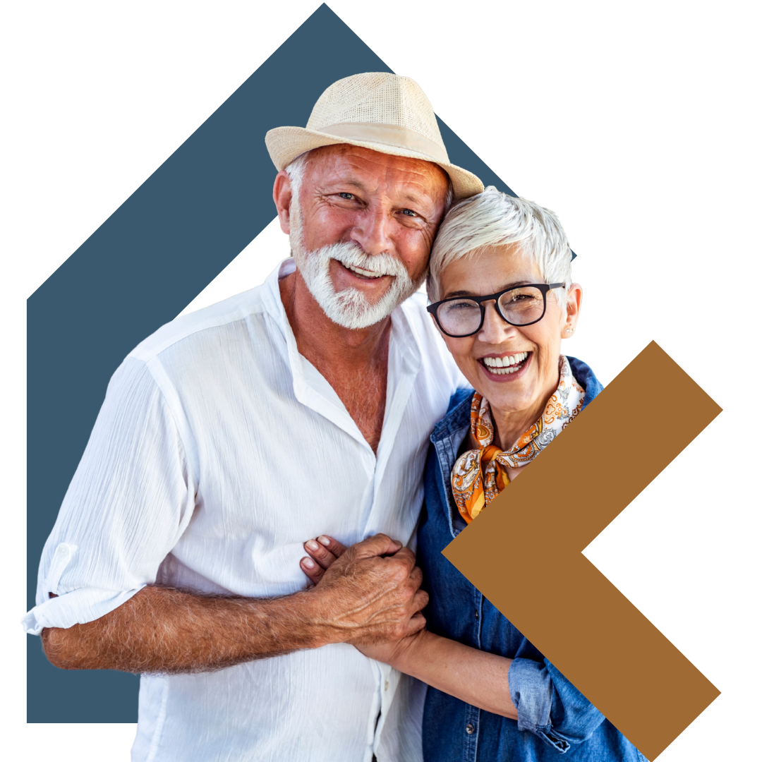 An elderly man with a white beard and a hat, smiling and holding hands with an elderly woman with short white hair and glasses, both looking happy.