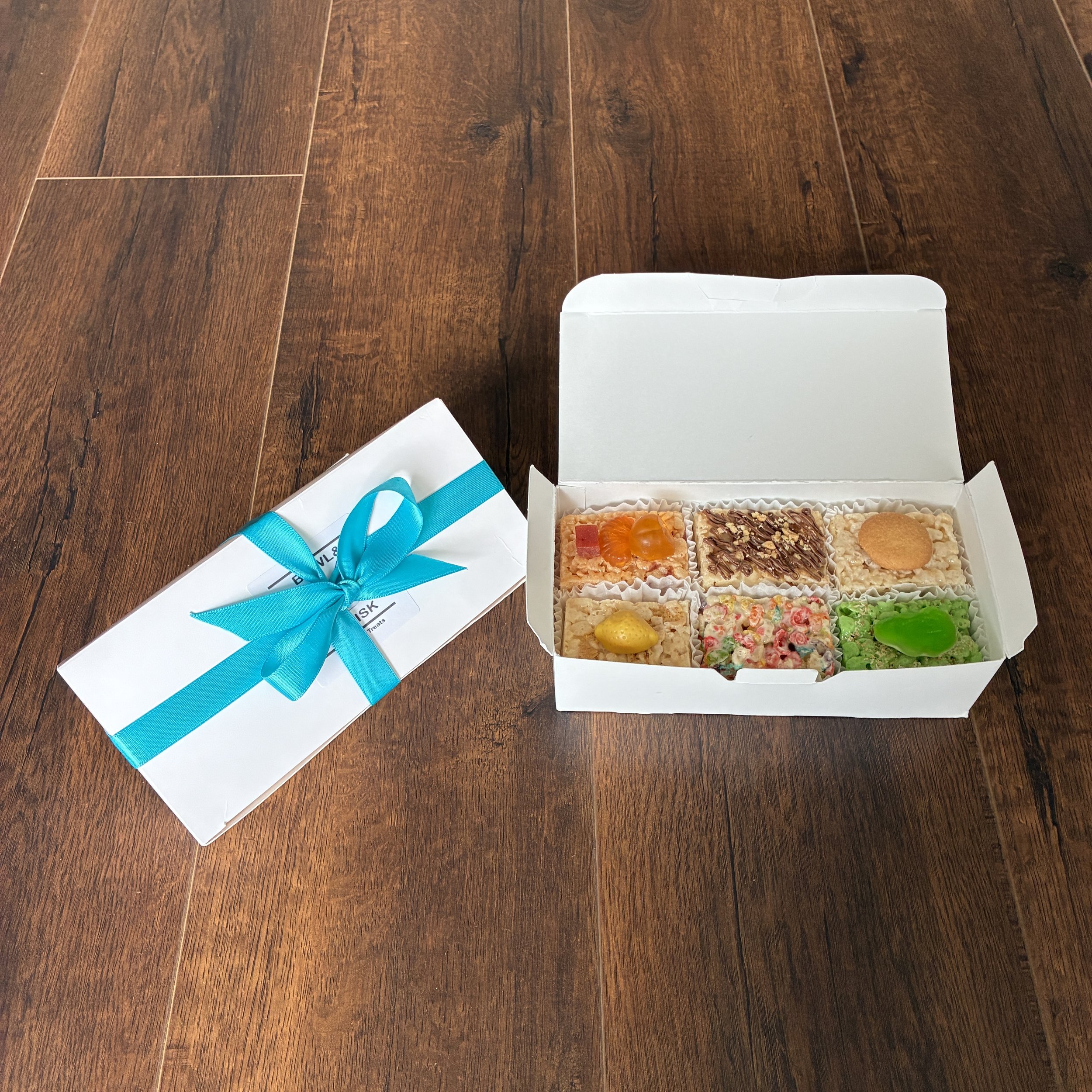 Our Sept 2026 Sampler Box of  Rice Crispie Treats, containing 1 piece each of banana pudding, guava matcha, rainbow pebbles, root beer float, strawberry margarita and strawberry shortcake flavors
