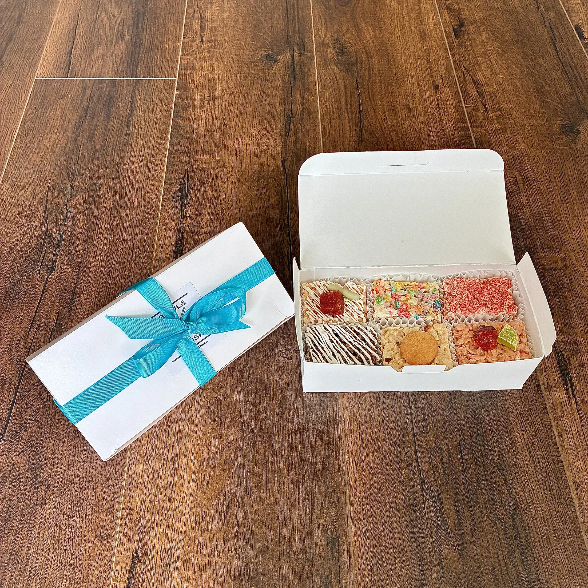 Our August 2026 Sampler Box of  Rice Crispie Treats, containing 1 piece each of banana pudding, guava matcha, rainbow pebbles, root beer float, strawberry margarita and strawberry shortcake flavors