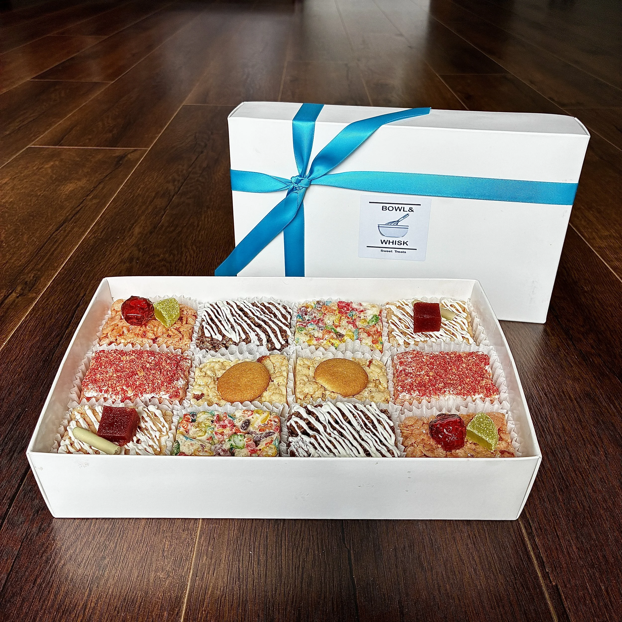 Our August 2026 Gift Box of Rice Crispie Treats, containing 2 pieces each of banana pudding, guava matcha, rainbow pebbles, root beer float, strawberry margarita and strawberry shortcake flavors