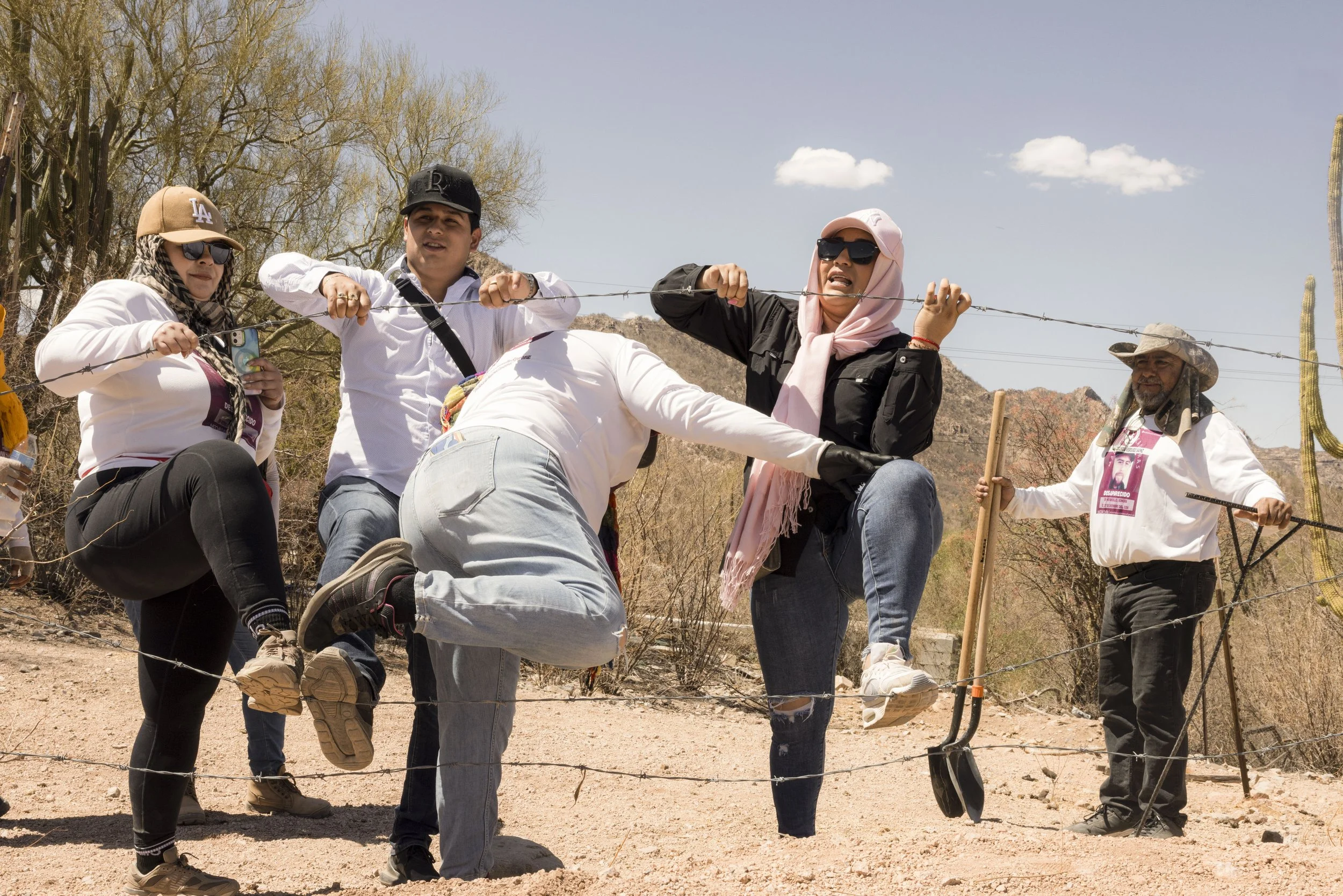 Members cross a barrier in the field.
Many sites are on private land.