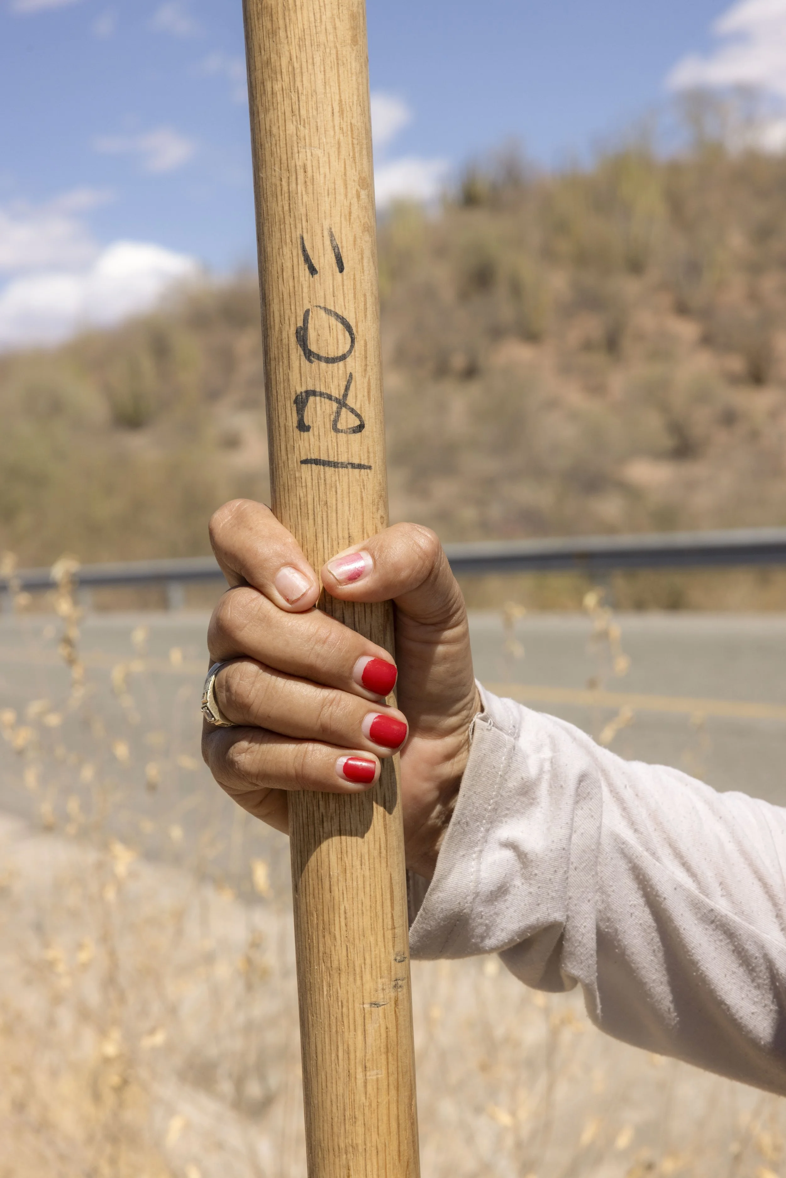 A woman's hand on a shovel handle.
In the field.