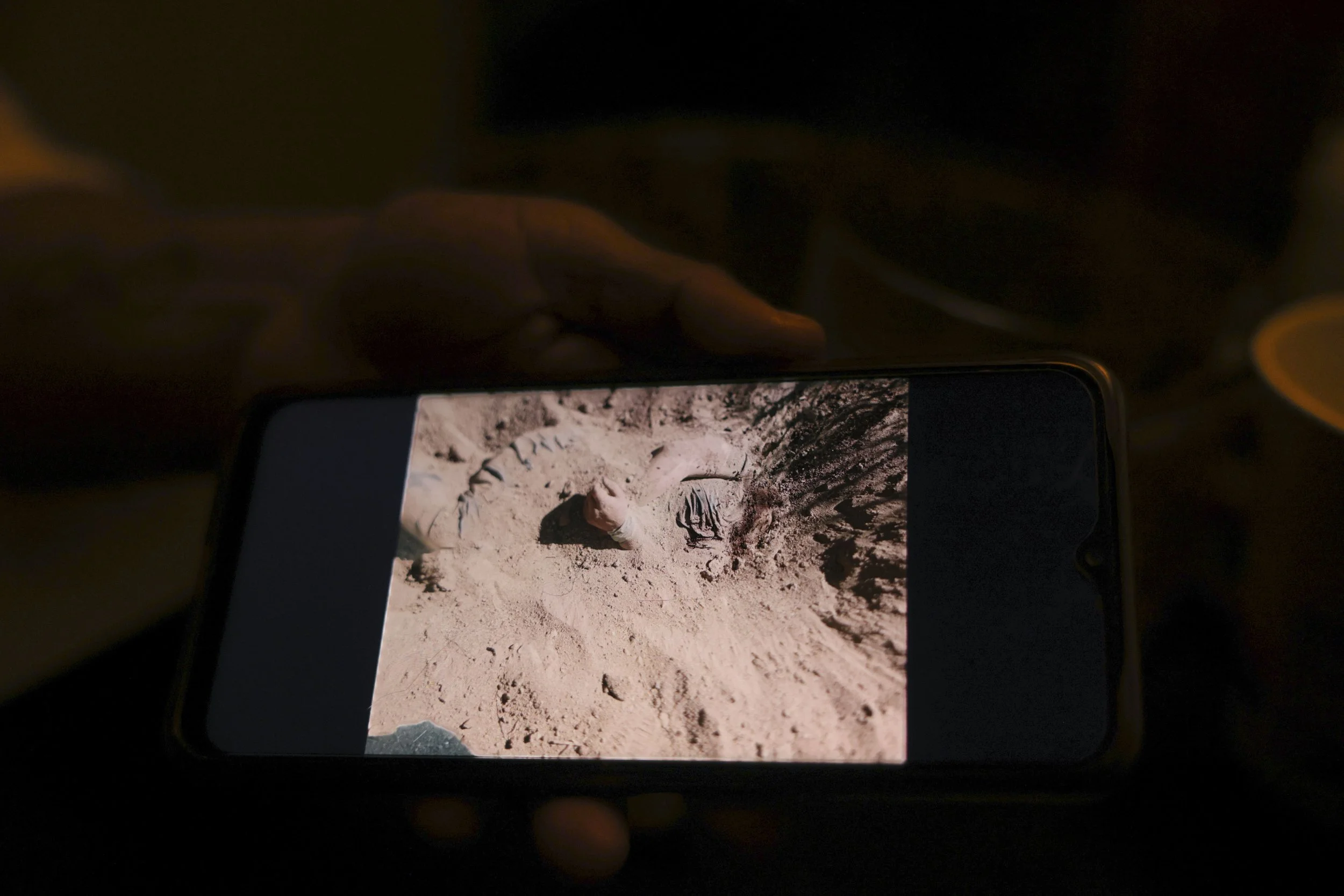 Ana Luisa shows a phone photo of a body, half-buried.
A fresh grave.