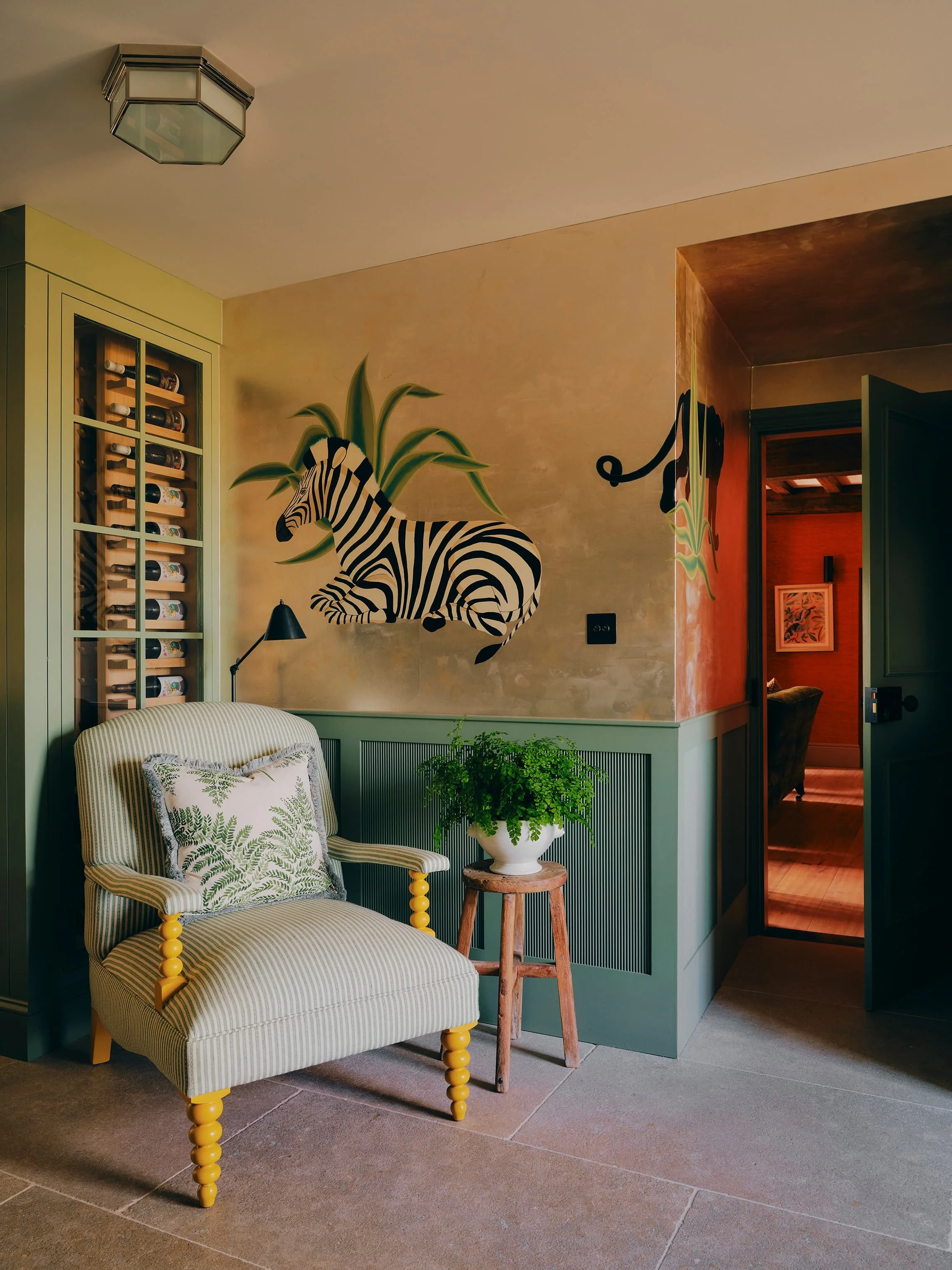 "Snug with zebra mural, built-in wine cabinet, and striped armchair in a Jersey rural rectory by Bryony Richardson"
