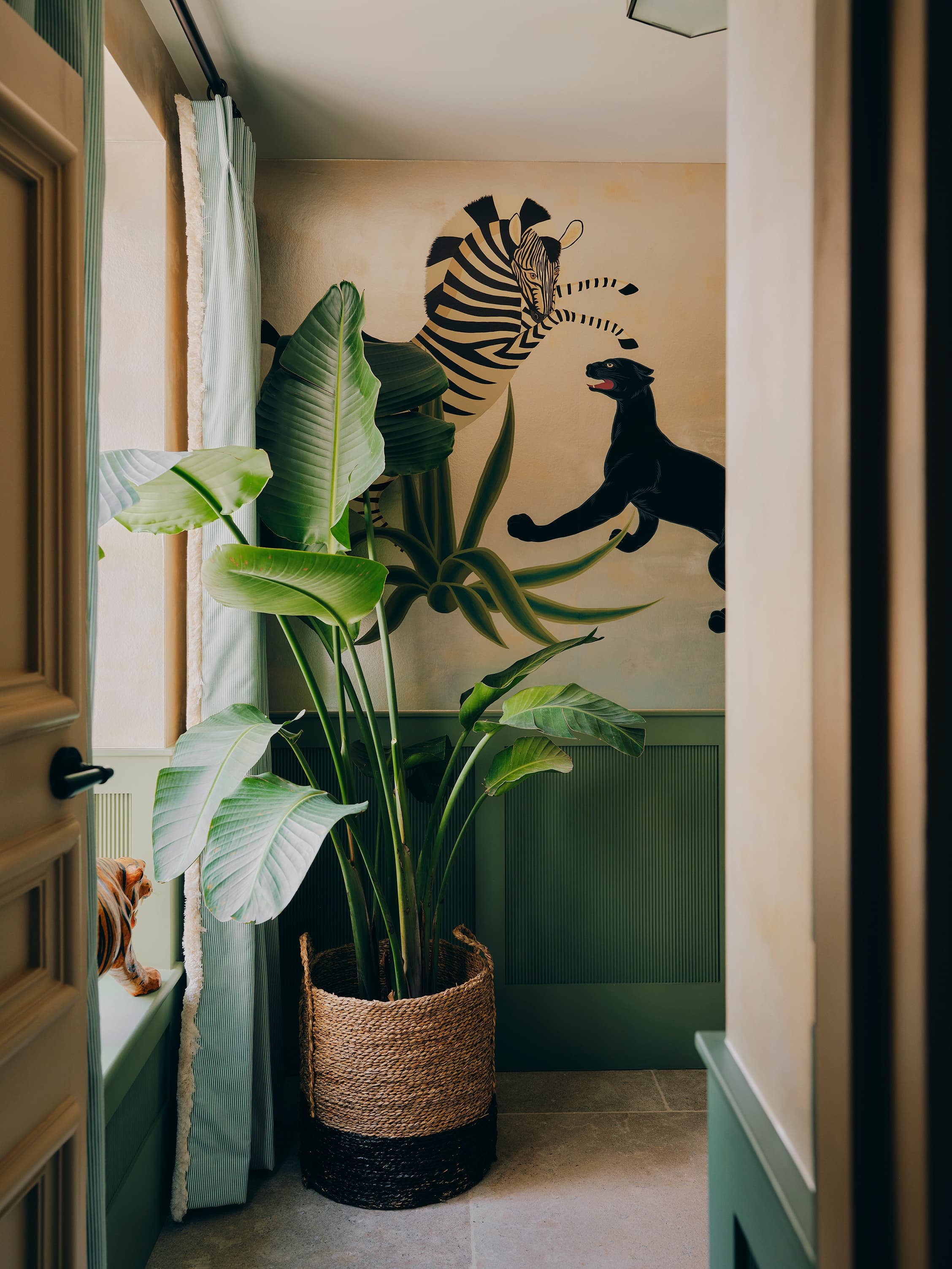 "Hallway with hand-painted zebra and panther mural in a Jersey rural rectory by Bryony Richardson"