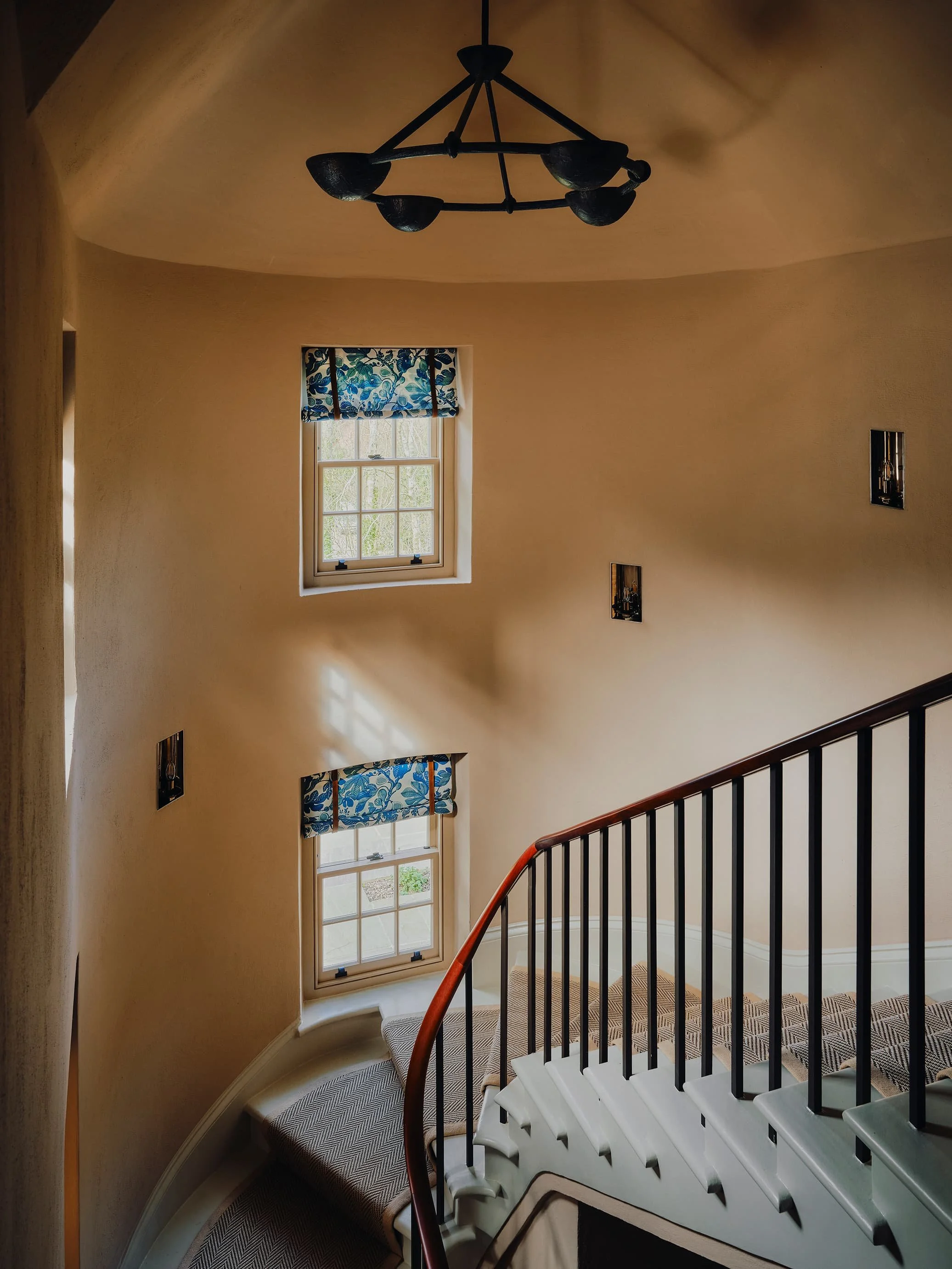 "Curved staircase with patterned floral blinds in a Jersey rural rectory by Bryony Richardson"