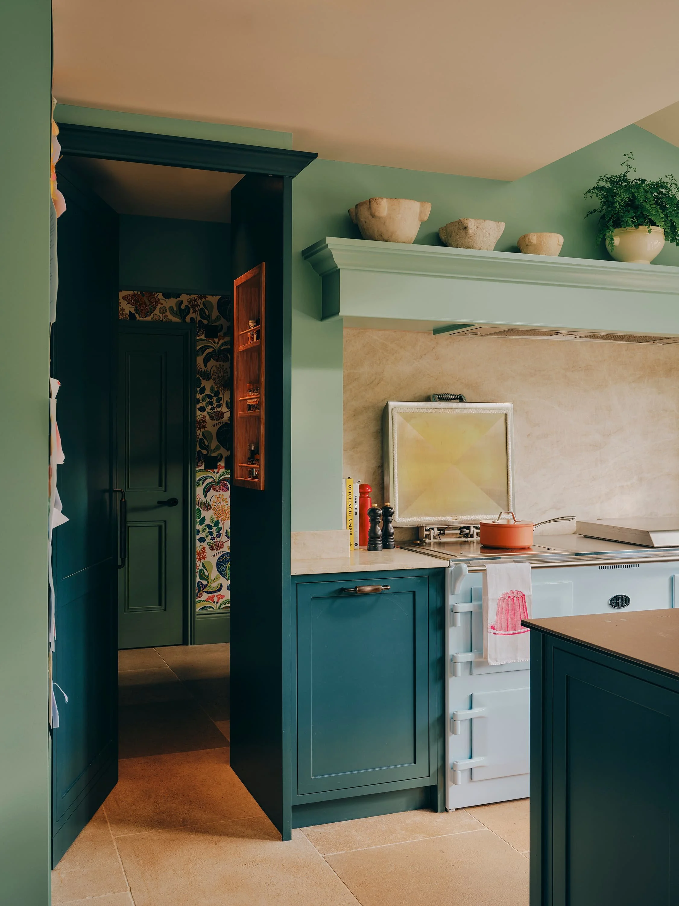 "Kitchen with green cabinetry and pantry doorway in a Jersey rural rectory by Bryony Richardson"