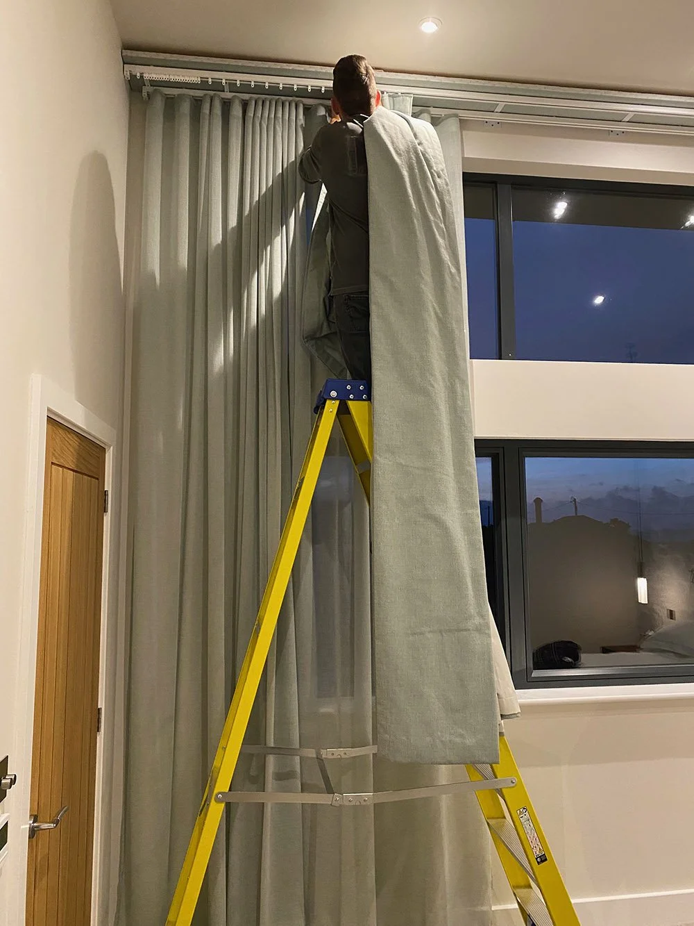 Person fitting our made to measure curtains in Cornwall