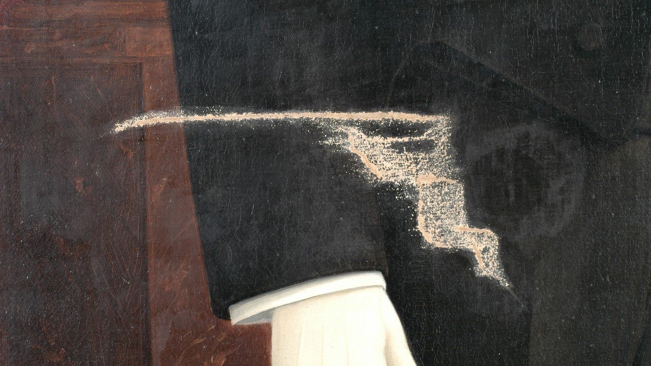 Dust and debris on a dark wooden or black surface next to a white object, possibly a chair leg or table leg.
