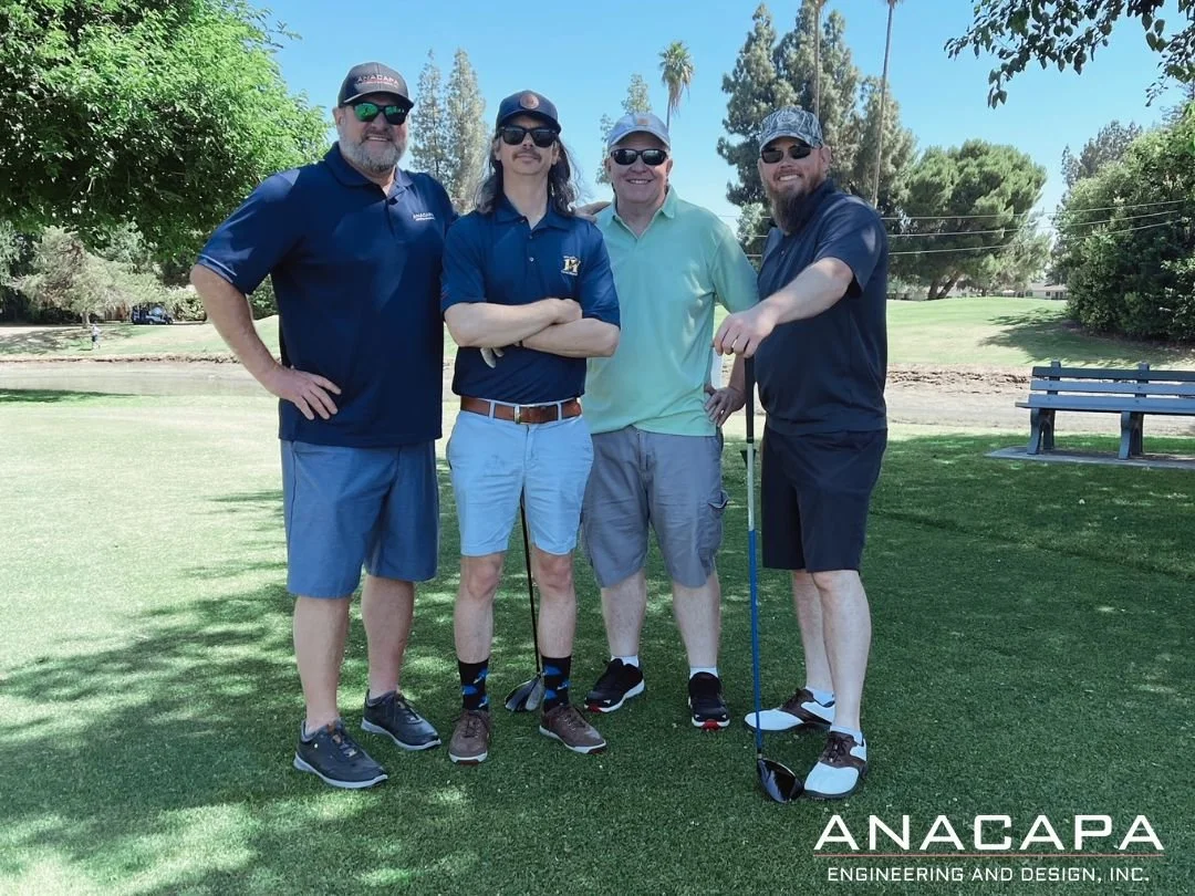Four men in casual clothing and sunglasses stand together on a golf course, hinting at a golf tournament. The logo "ANACAPA ENGINEERING AND DESIGN, INC." appears in the bottom right.