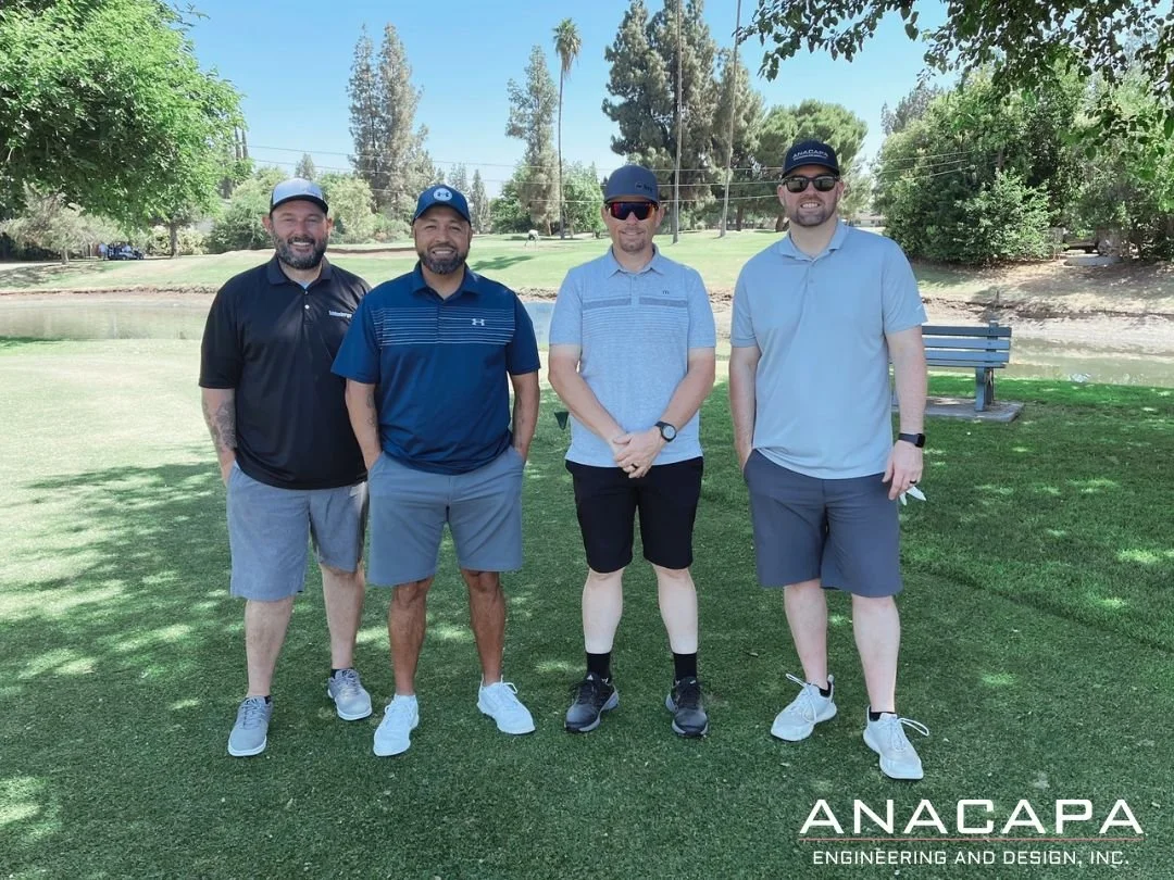 Four men in golf attire stand side by side on a golf course with trees and a pond in the background. The words "ANACAPA Engineering and Design, Inc." are in the bottom right corner of the image.