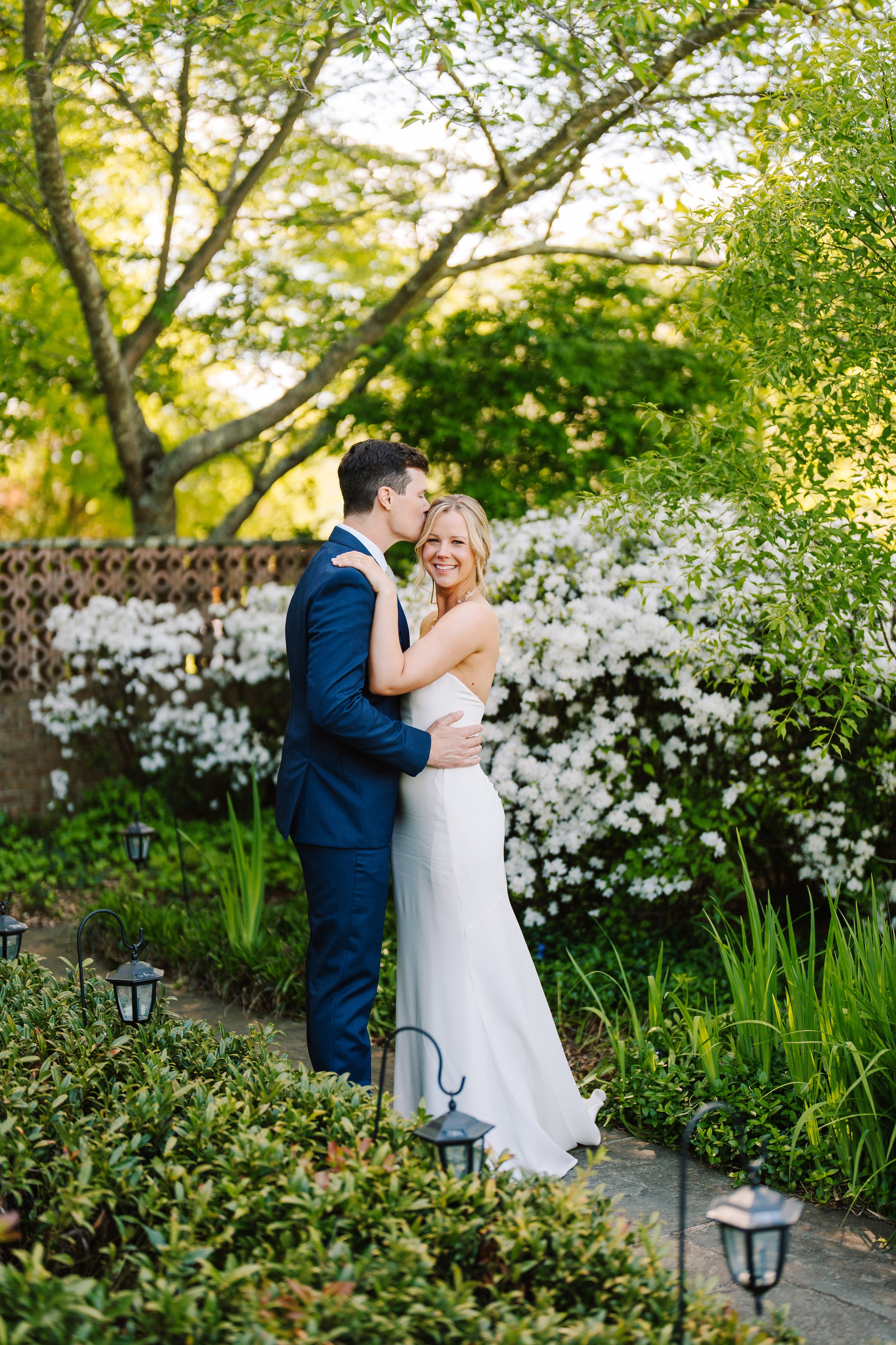 Groom kissing his bride's forehead.