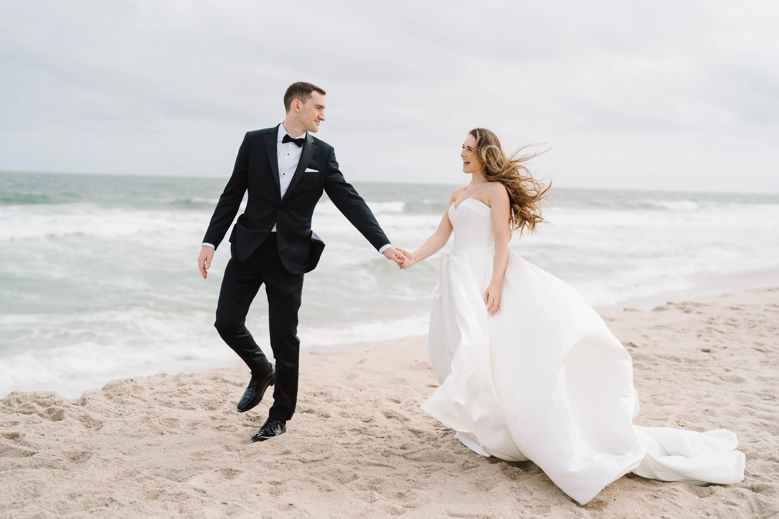 Bride and Groom walk on the beach during portraits at Park Pavilion