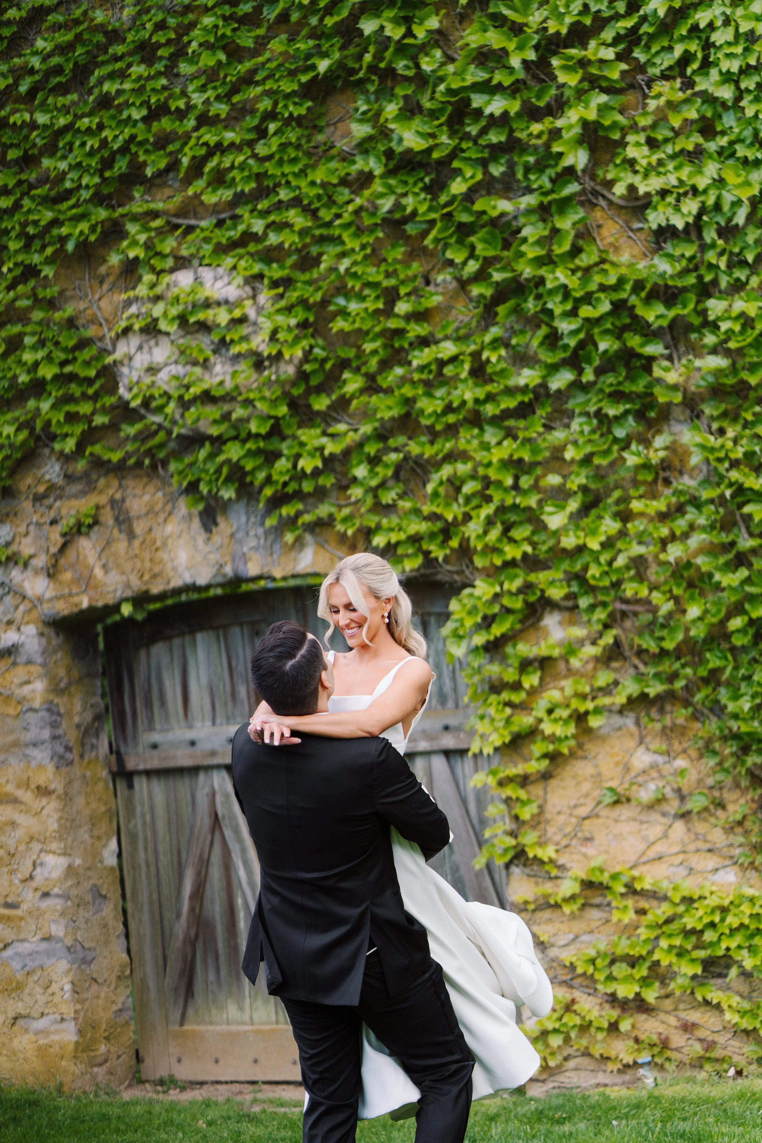 Groom lifting and spinning his bride.