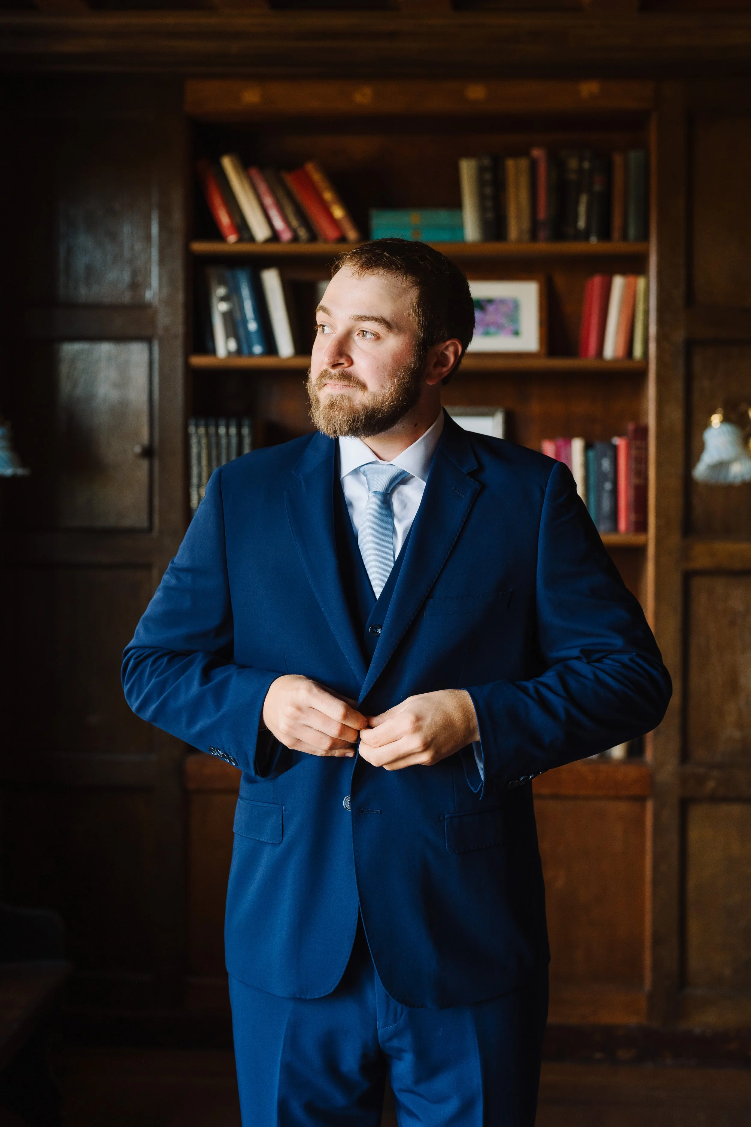 Groom getting ready in the library of the mansion