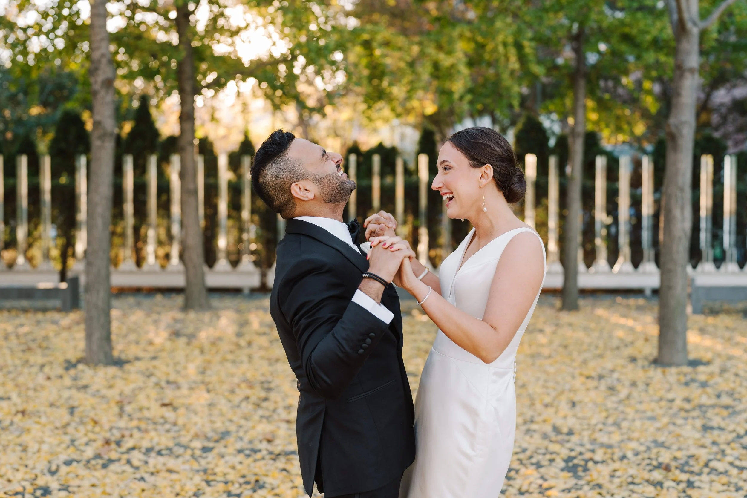 Bride and groom hold hands and laugh at their first look.