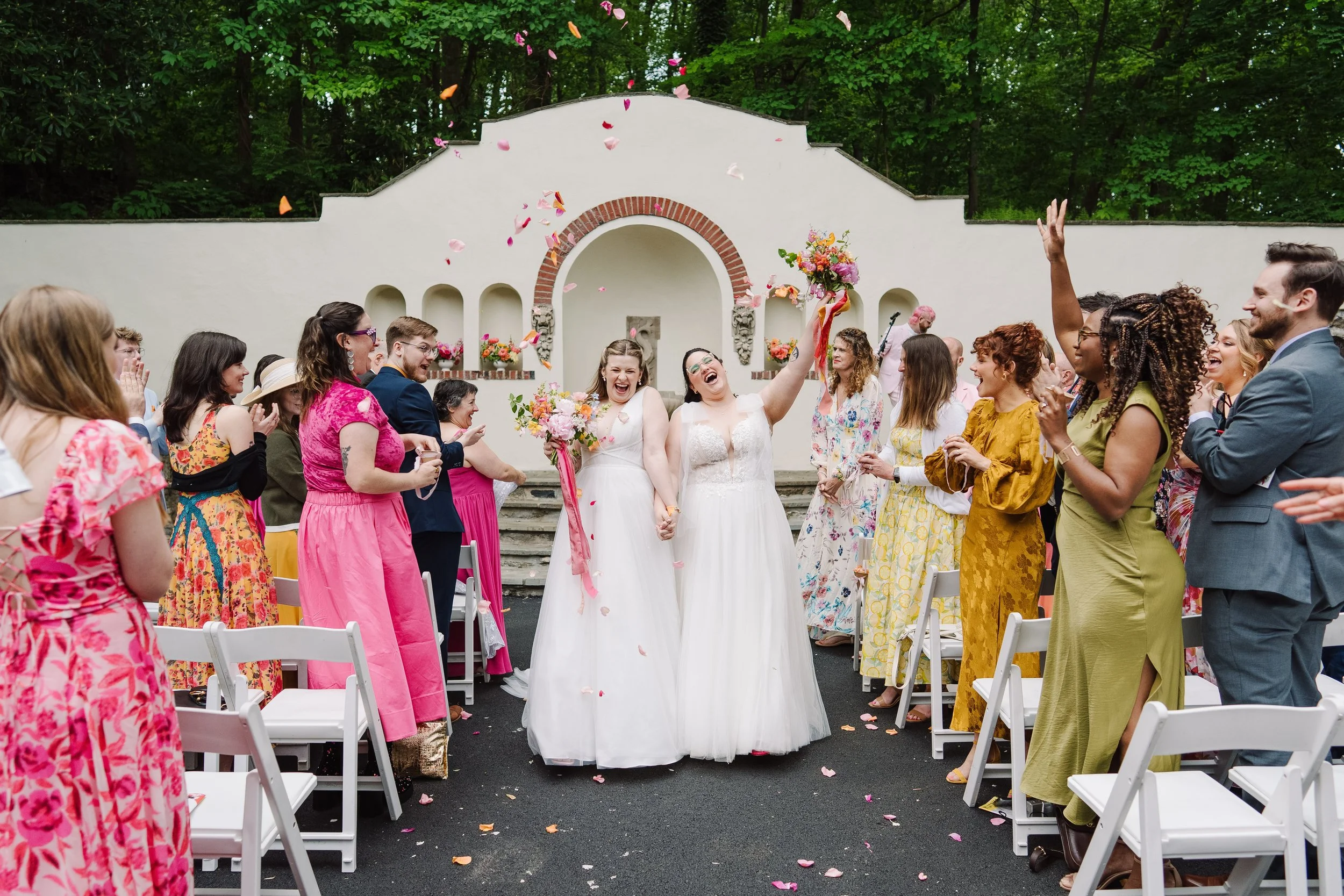 Brides celebrate as they recess down the aisle.