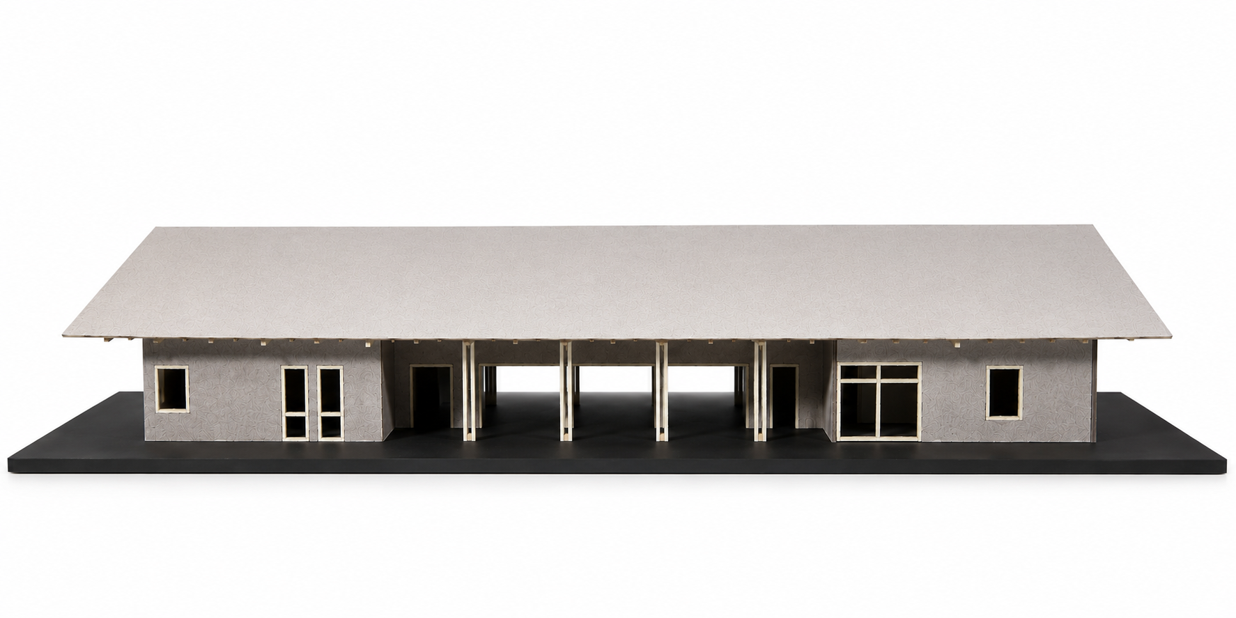 Physical architectural model of Kona House in Hawaii showing the long elevation, deep roof overhang, open breezeway, structural posts, and residential spaces.