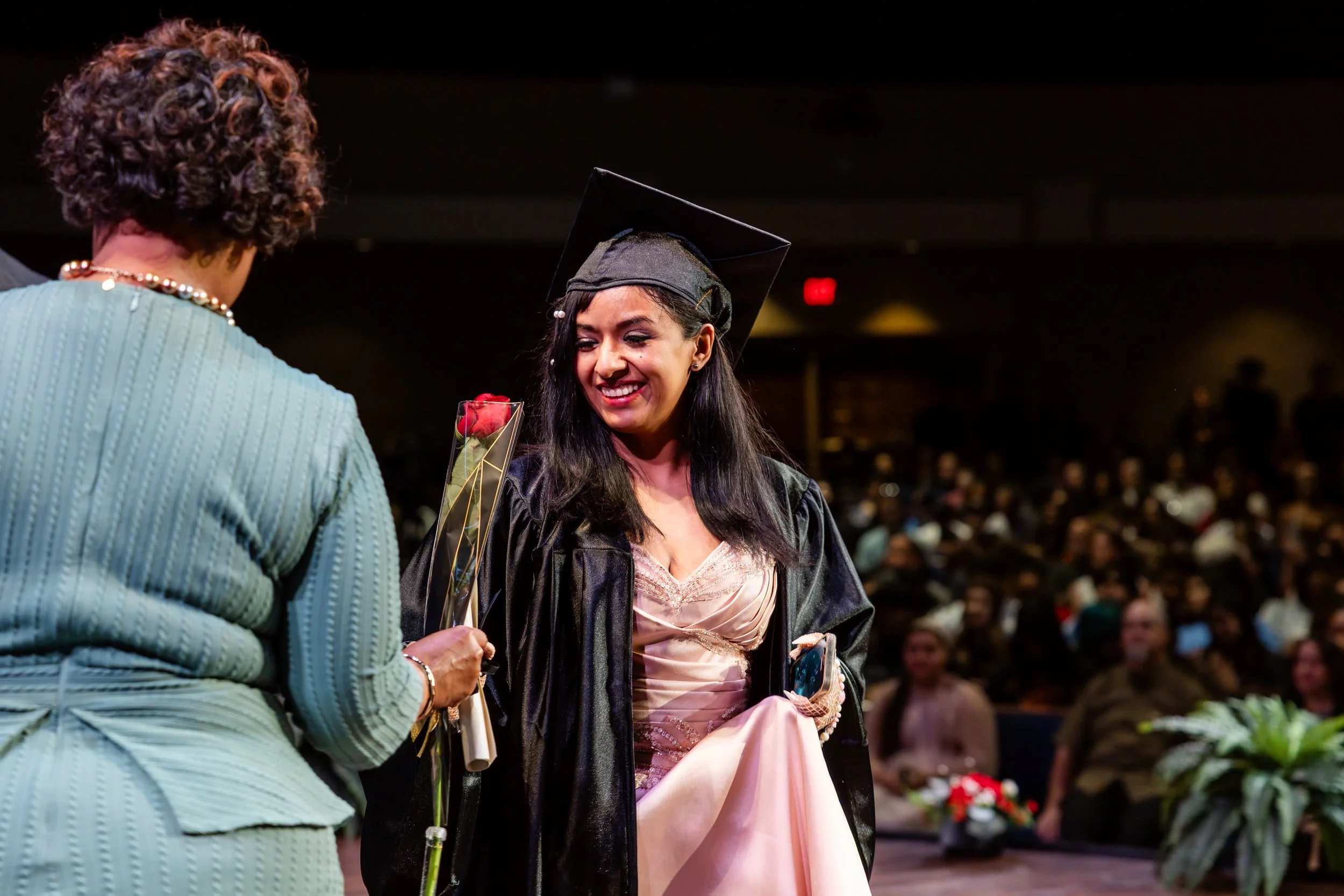 Graduate walking across the stage and receiving their diploma