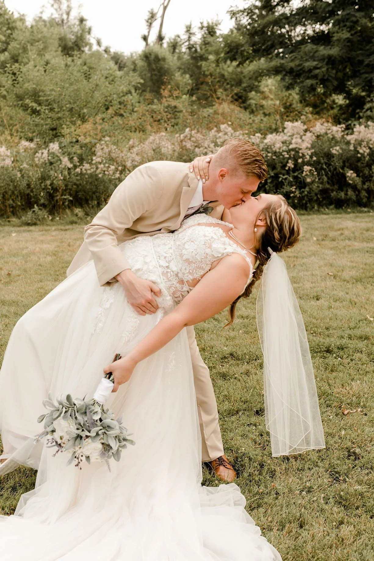 Bride and groom celebrating during an outdoor wedding ceremony surrounded by natural scenery.