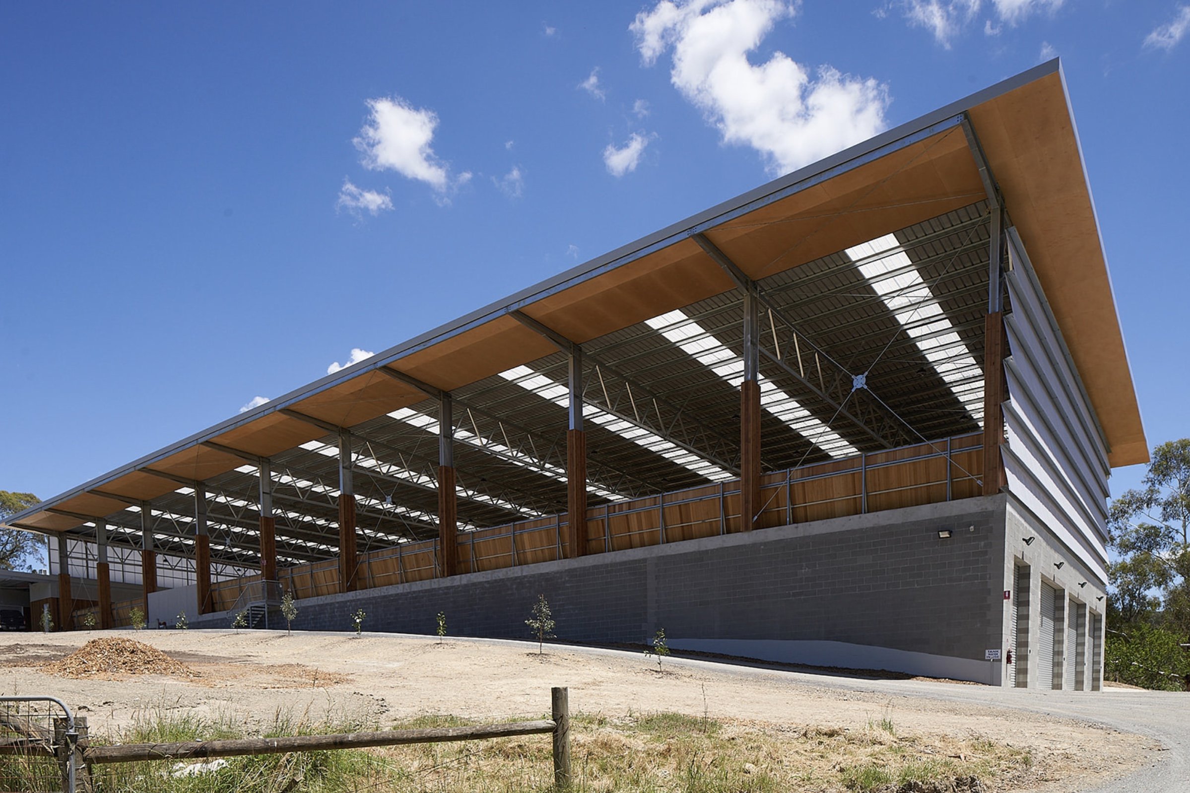 covered outdoor stable arena, featuring a protected space for horses to exercise and train, shielded from the elements