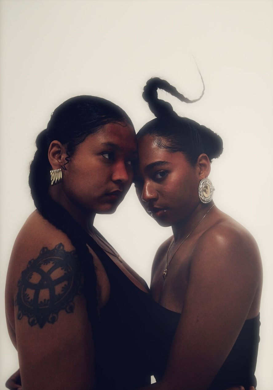 Spectrum
(30x40in):

A portrait of contrast, light & dark, side by side, eye to eye. Too often, this divide among black women is not always spoken about, but deeply felt. 

Here, it is not denied, it's embraced. Two bodies. One gaze. One hold. The di