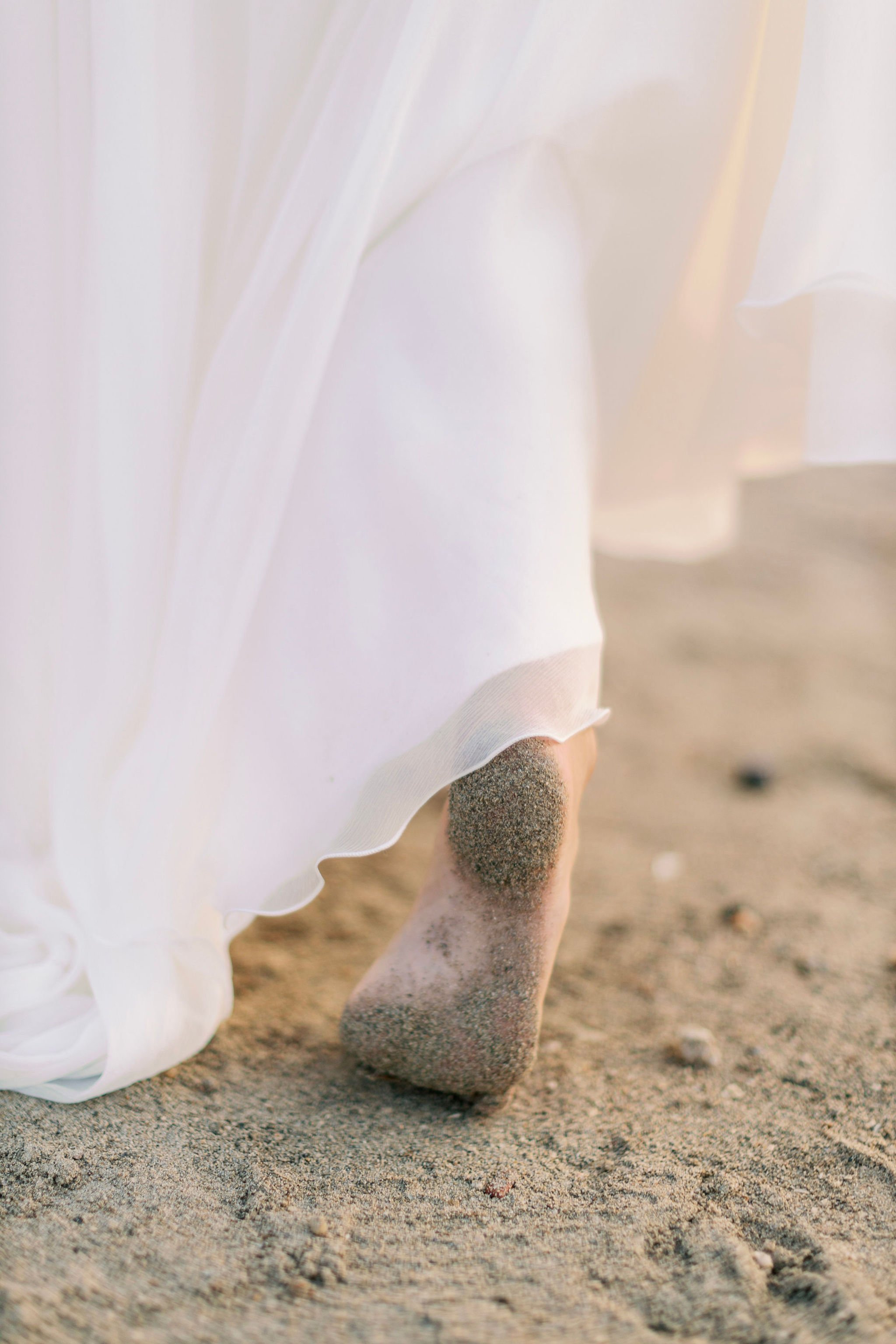 bride walking barefoot on the beach