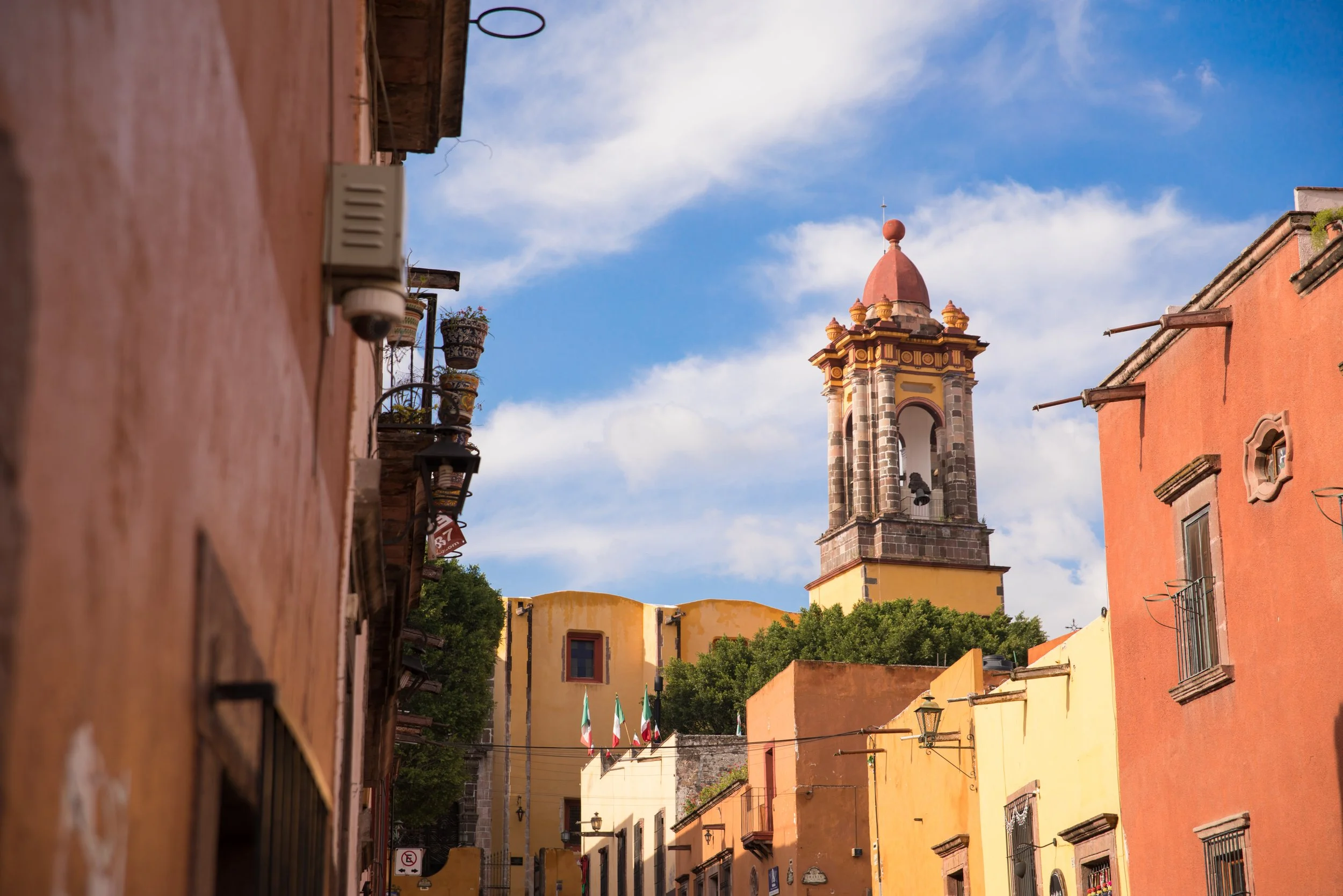 a street in San Miguel de Allende with warm-colored buildings