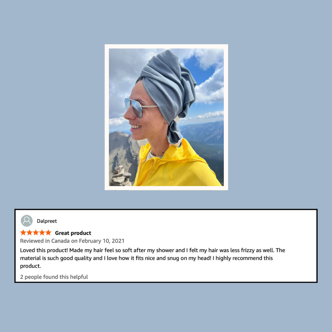 Customer photo of a woman wearing grey  KAZKA hair towel outdoors with mountains in the background, alongside her product review, she loves taking it with her for travelling and hikes. 