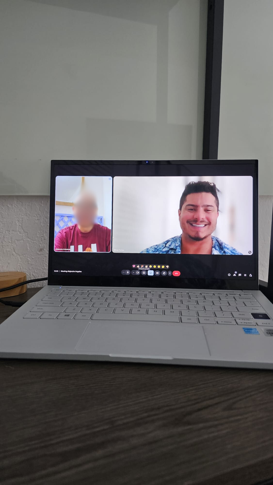 A screenshot from a video call showing a person wearing a beige Calvin Klein shirt, sitting in a car, with their face blurred. The car's interior, including the headrests and seatbelt, is visible, and through the window, a parking lot with other cars can be seen.