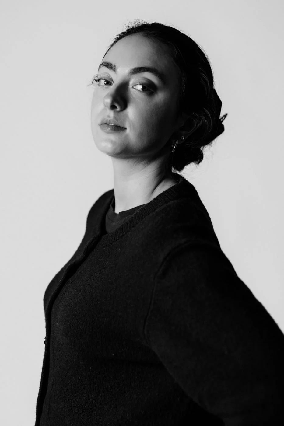 Black and white portrait of a woman with short hair, wearing a dark sweater, looking confidently at the camera.