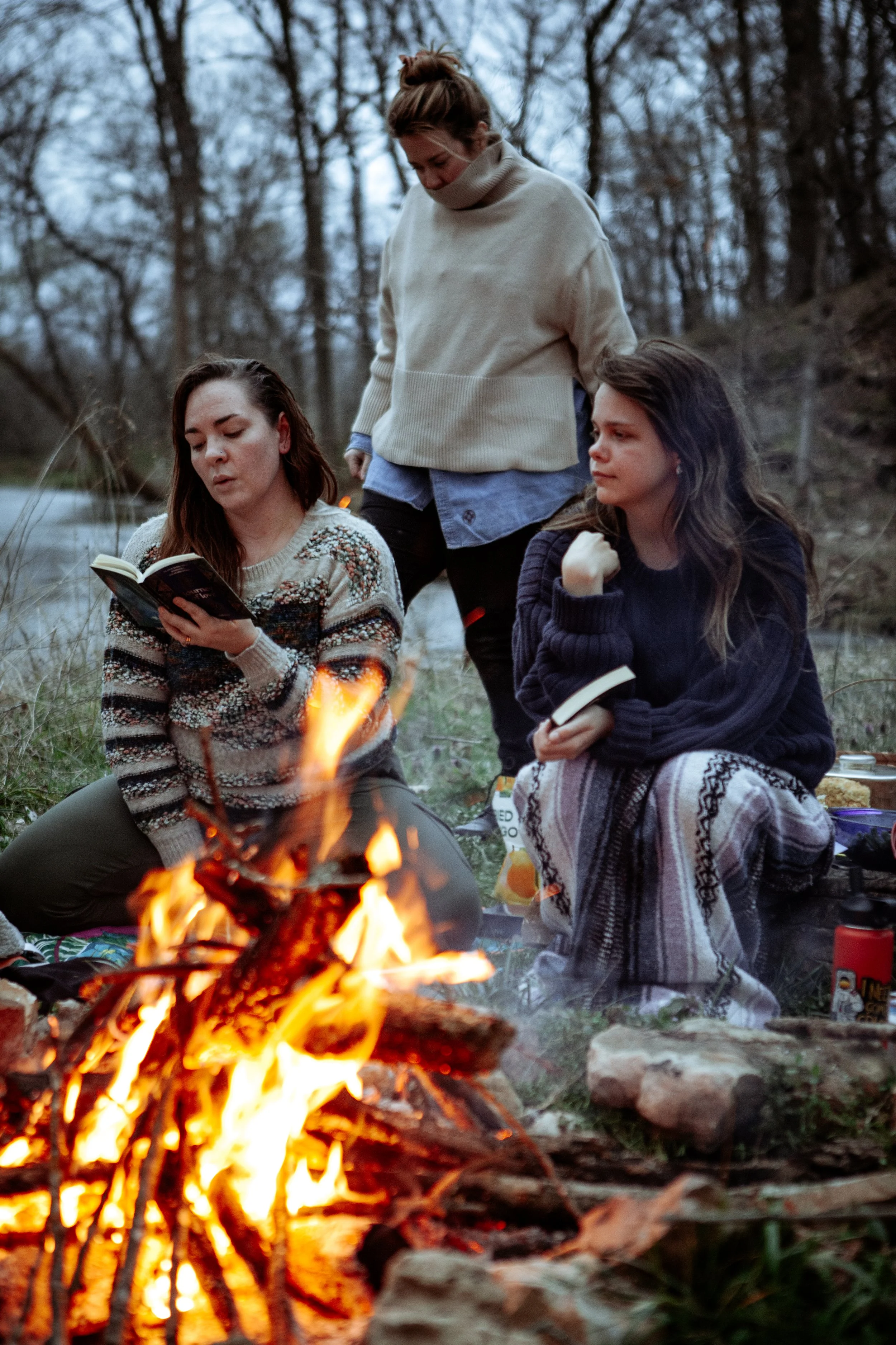 women reading to each other in the woods around a fire Springfield MO