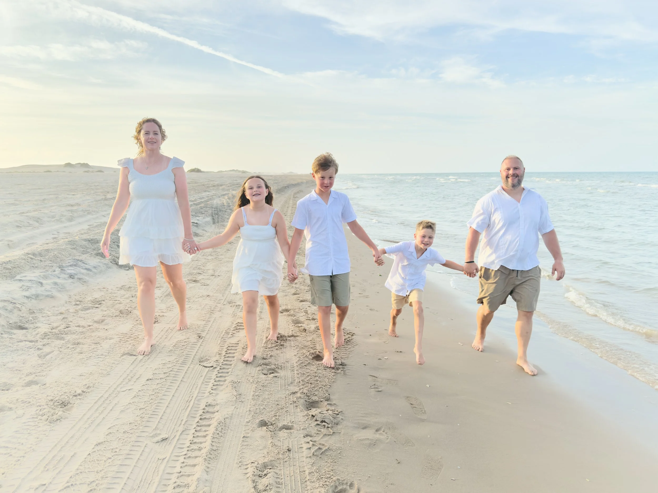 Family walking along the shoreline during a South Padre Island beach photography session