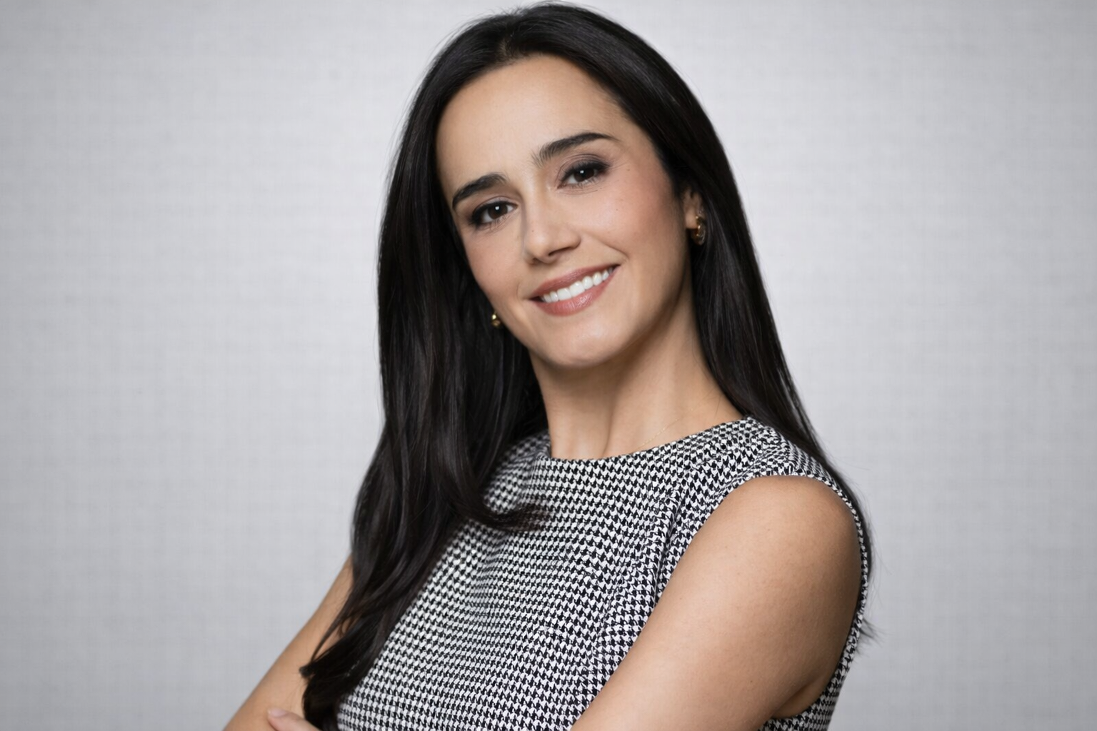 Confident smile in houndstooth attire.png