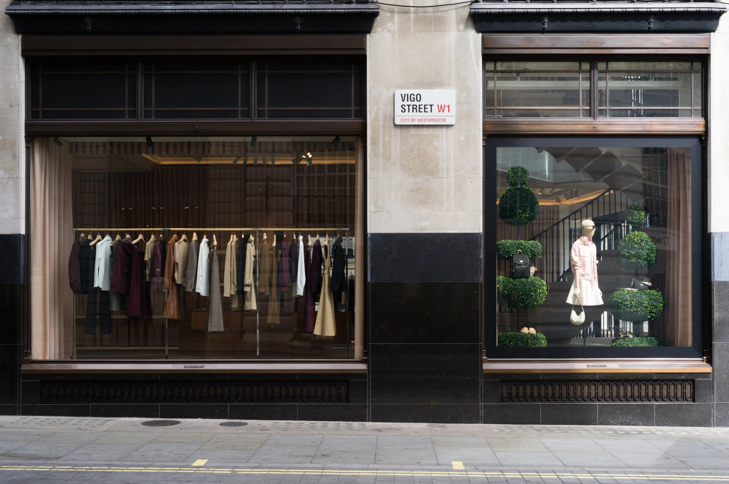 Storefront with clothing displays, mannequin with sunglasses and handbag, street sign showing Vigo Street, W1, City of Westminster.