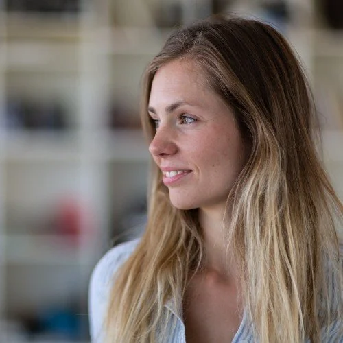 Woman with long blond hair looking to the side, blurred background