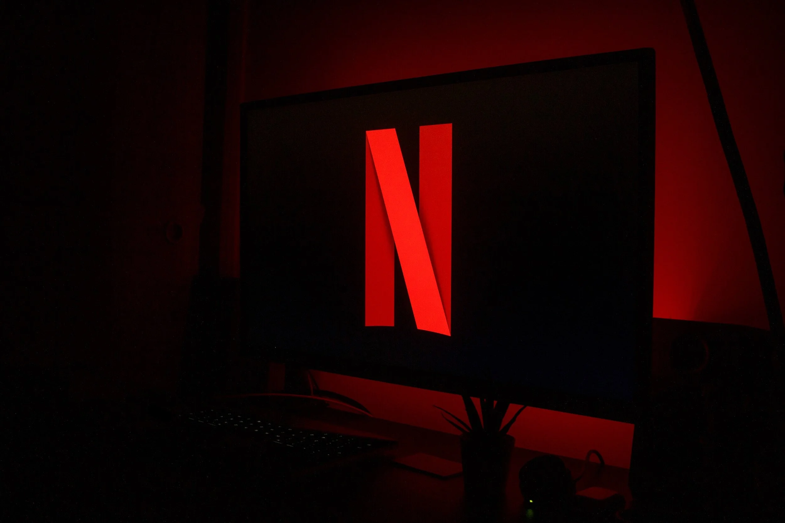 Monitor displaying Netflix logo with red lighting.