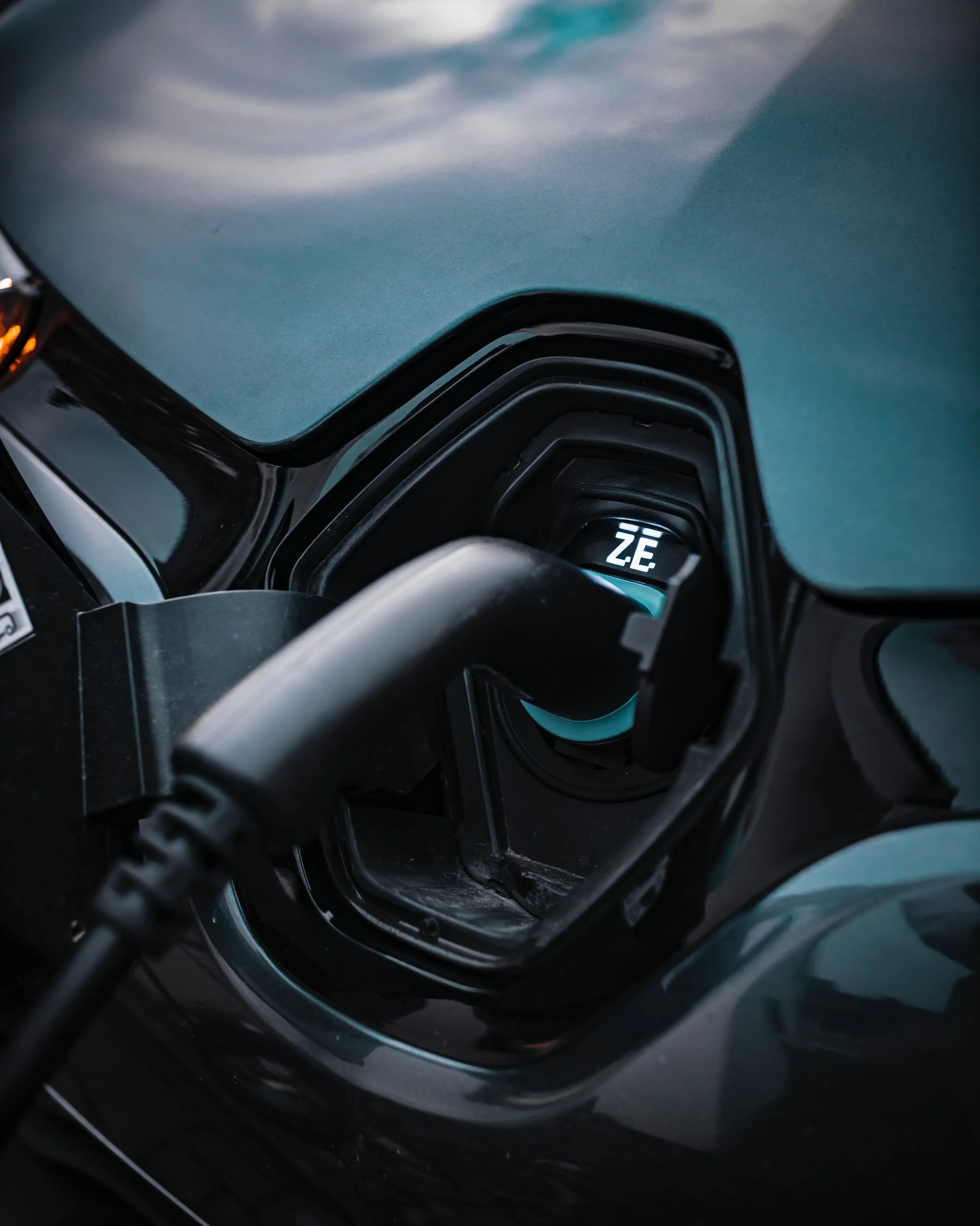 Electric vehicle charging port with charger inserted.