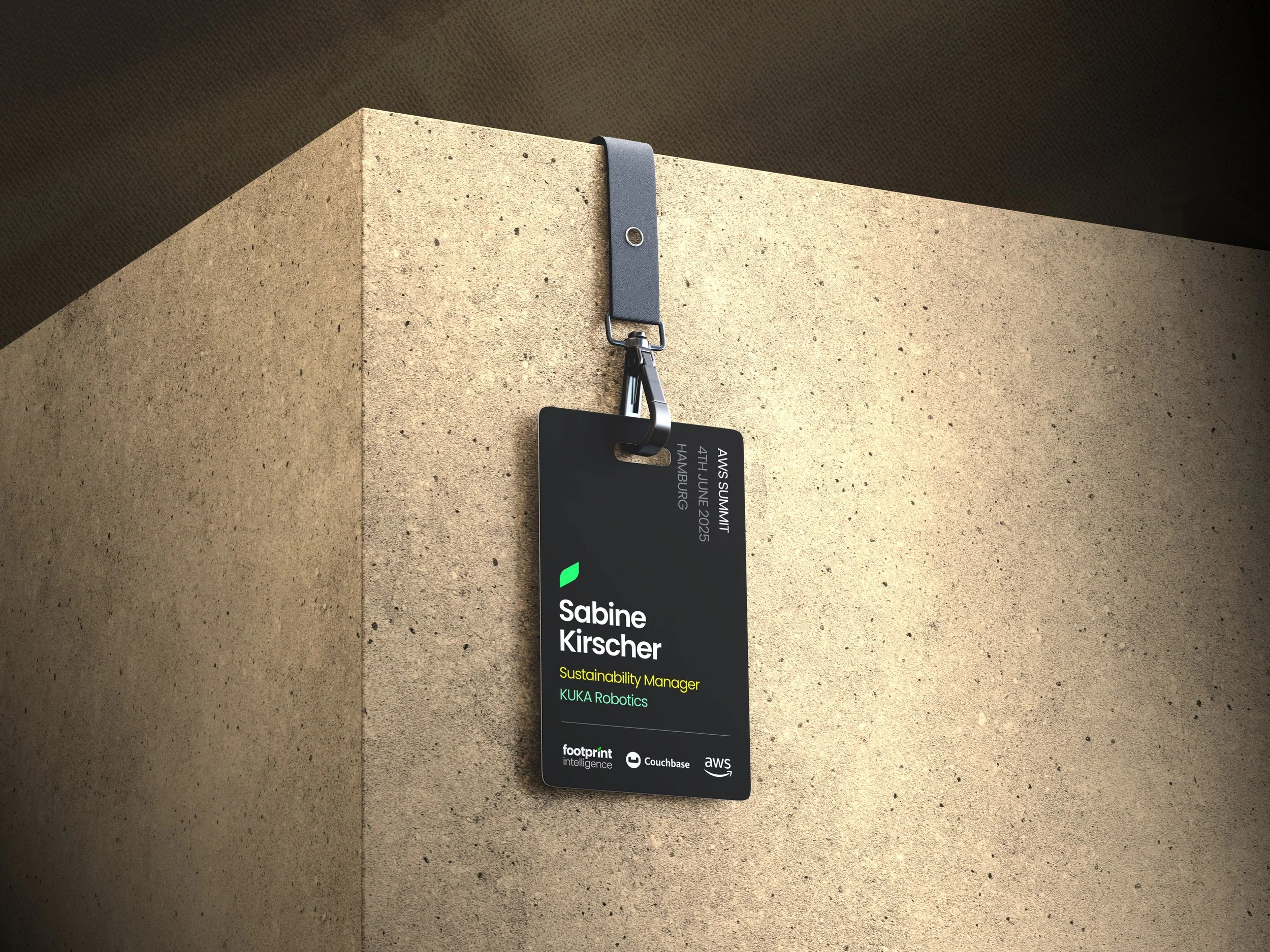 A black lanyard with an identification badge hanging on a concrete textured surface. The badge includes text indicating a name, title, and company, as well as the event 'AWS Summit' with details of the date and location. The badge also features logos of various companies.